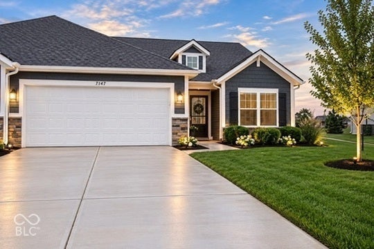 7141 Lillian Place, Cumberland, IN 46229 Exterior with dark siding, stone accents, white garage door