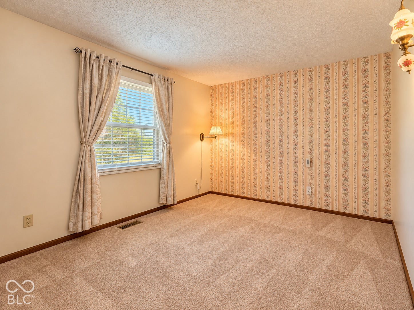 3680 S State Road 75, Coatesville, IN 46121 Textured carpet flooring, window with blinds, decorative wall sconce, and patterned wallpaper accent wall