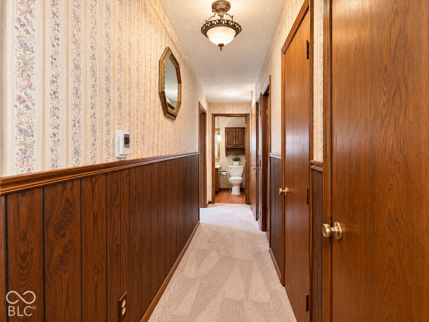 3680 S State Road 75, Coatesville, IN 46121 Hallway featuring wood paneling, wall-mounted light fixture, and carpeting