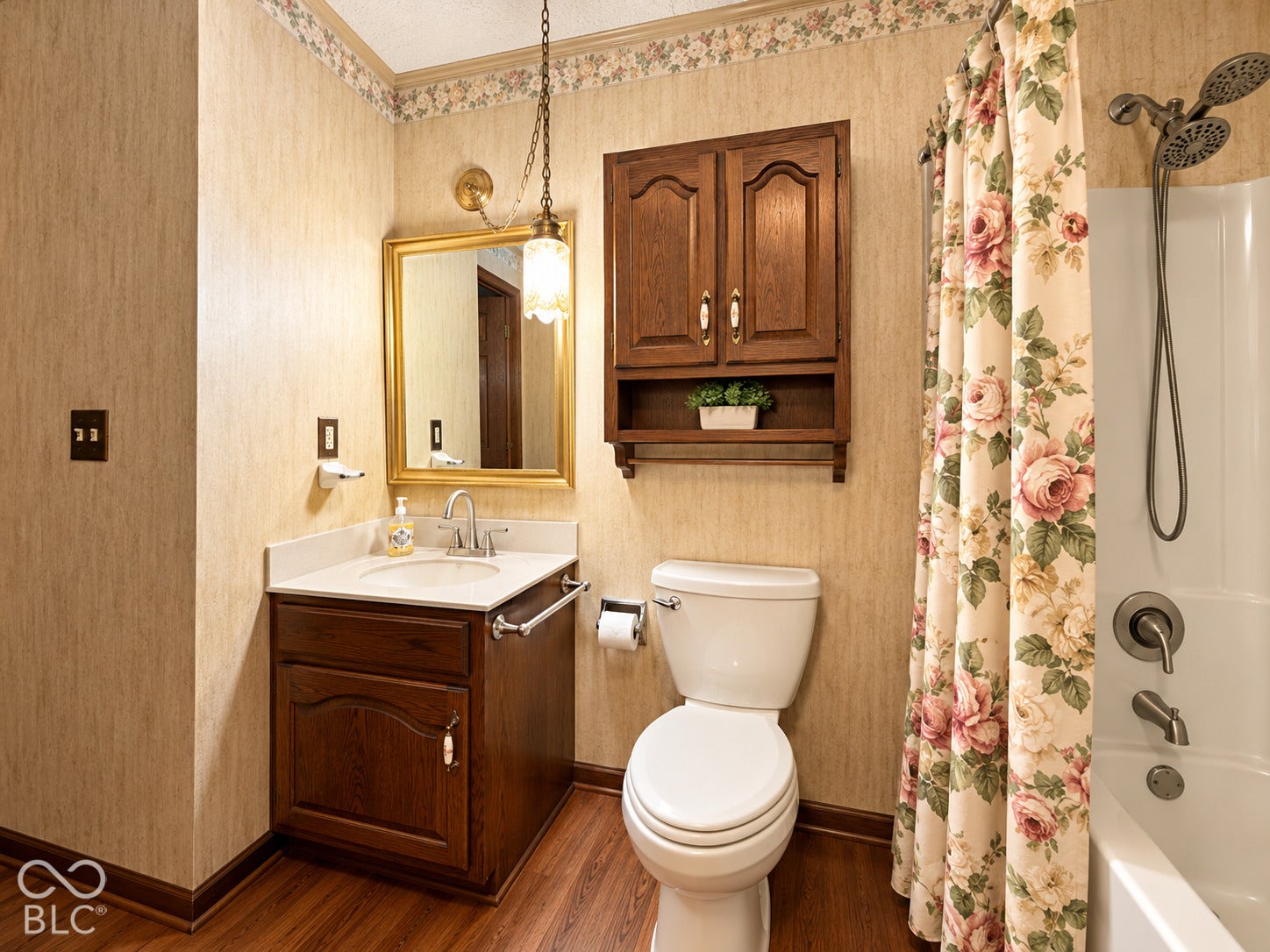 3680 S State Road 75, Coatesville, IN 46121 Bathroom featuring a wood-finish vanity with a white countertop and integrated sink, a matching wall-mounted cabinet, and wood-finish flooring