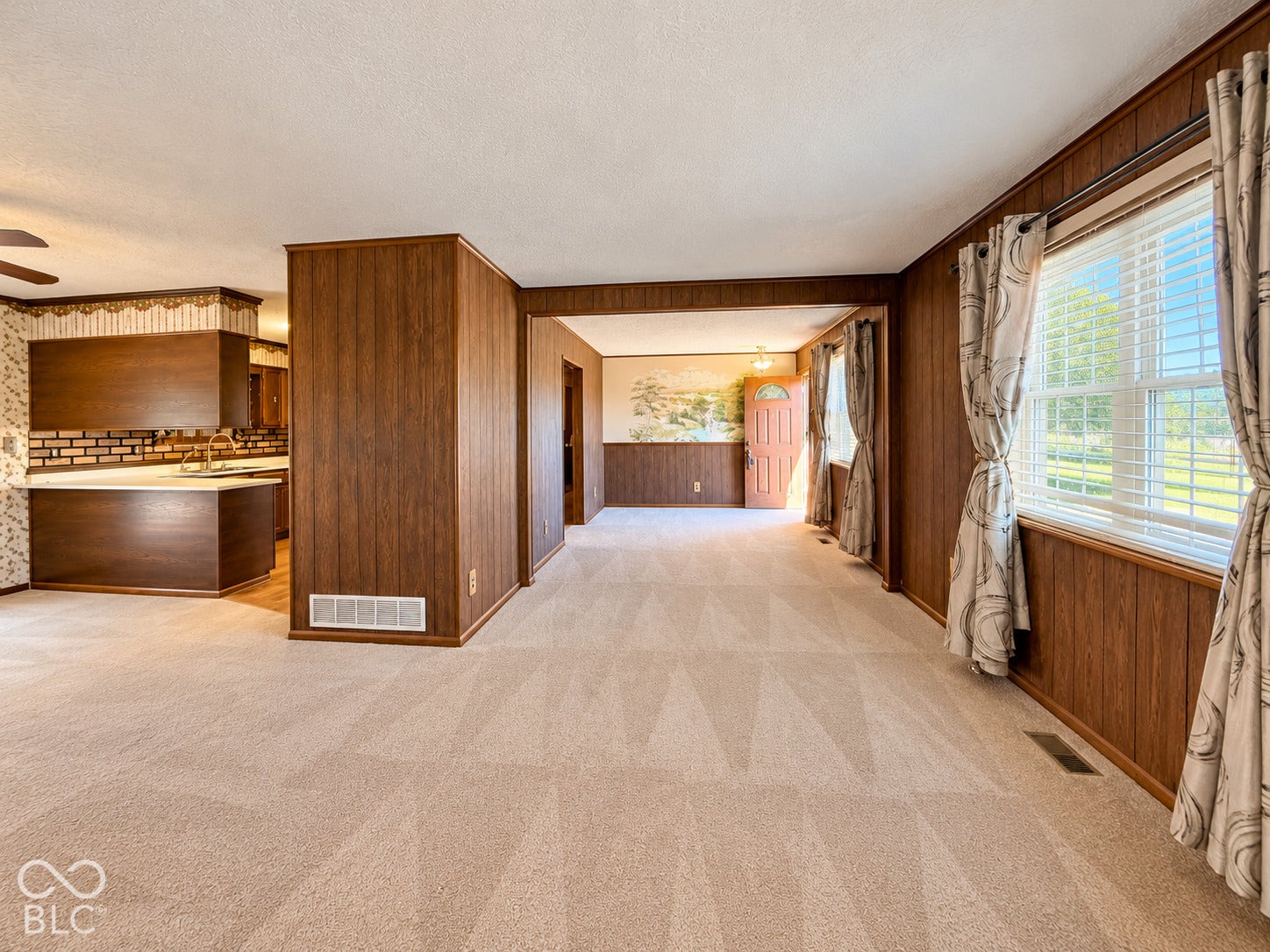 3680 S State Road 75, Coatesville, IN 46121 Carpeted flooring, wood paneling, a large window, and a ceiling fan