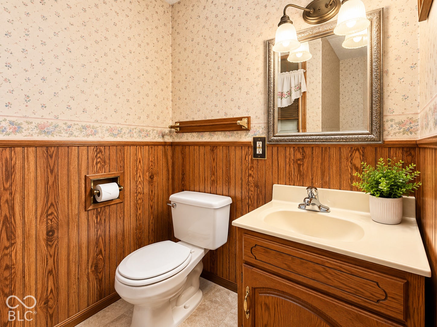 3680 S State Road 75, Coatesville, IN 46121 Wood-paneled wainscoting with patterned wallpaper above, white toilet, and a vanity with an integrated sink