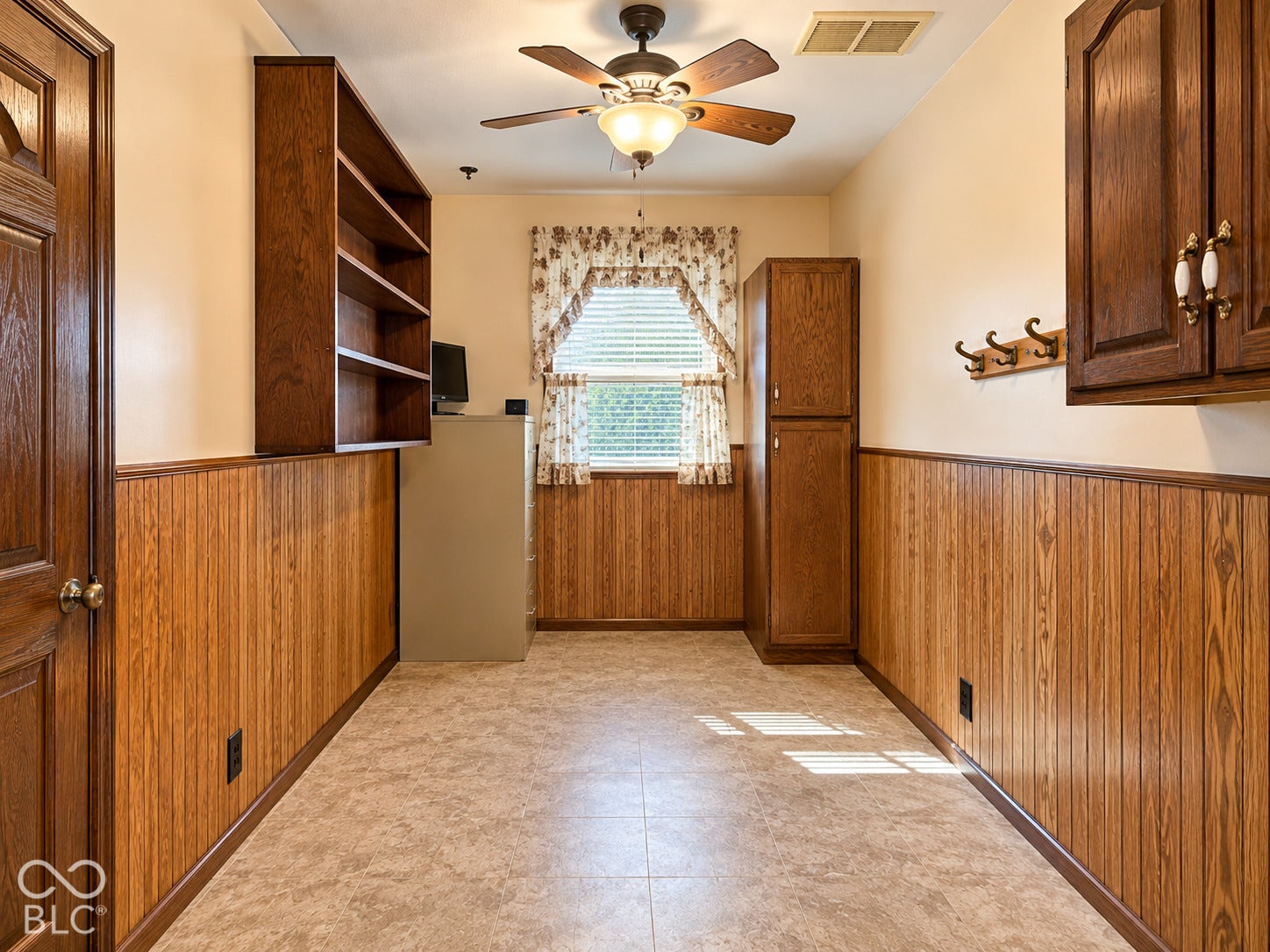 3680 S State Road 75, Coatesville, IN 46121 Wood-panel wainscoting, built-in shelving, ceiling fan with integrated lighting, and a built-in storage cabinet
