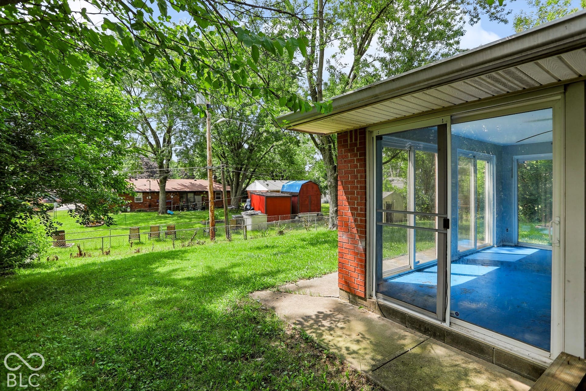 Enclosed patio with full-height glass panels and sliding door