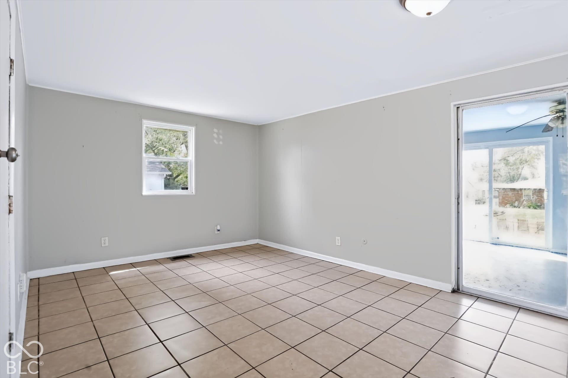 Neutral wall color, ceiling-mounted light fixture, and tile flooring