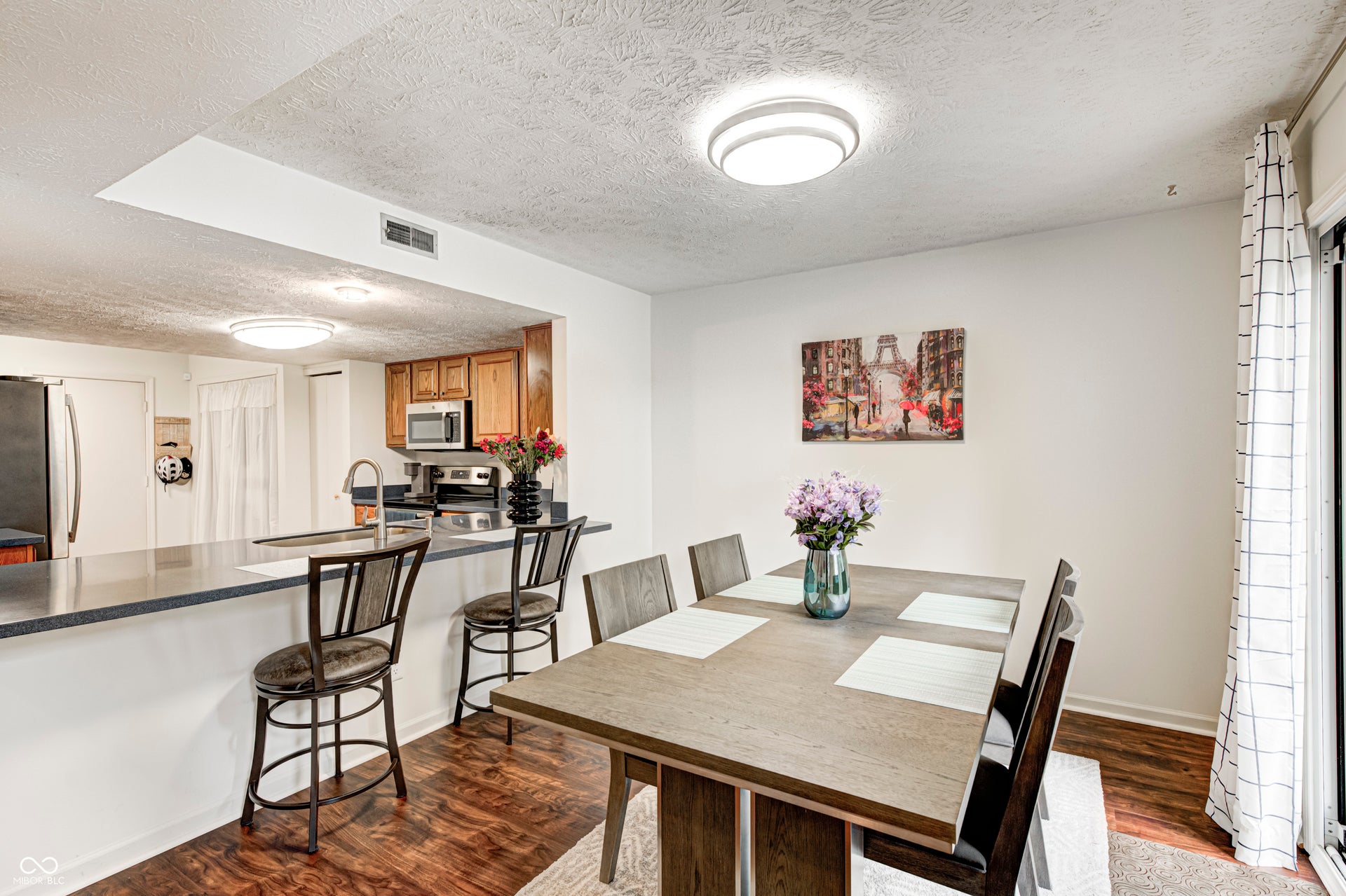 dining space with a textured ceiling and dark wood-style flooring