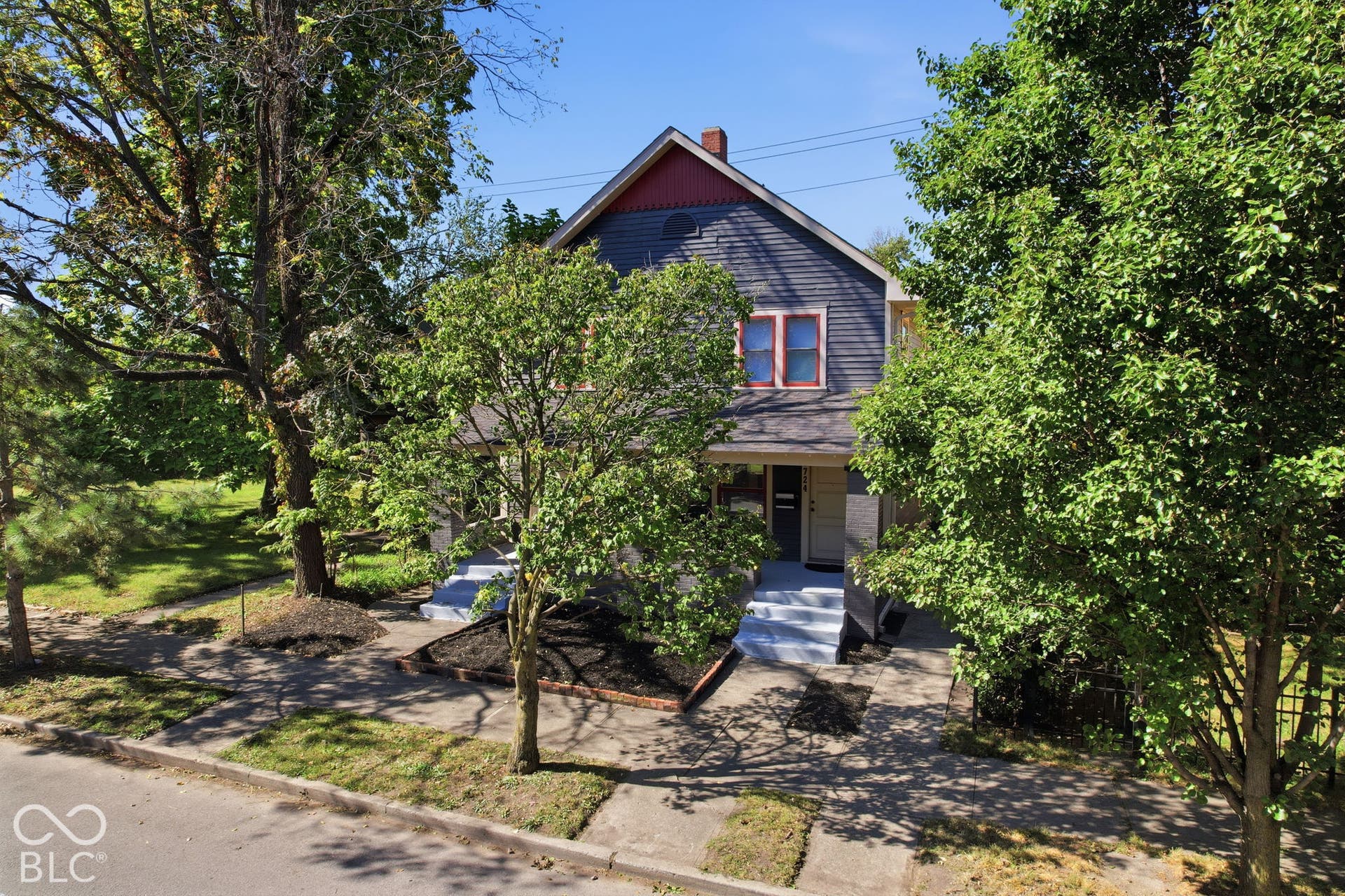 Two-story exterior with dark siding and red trim accents