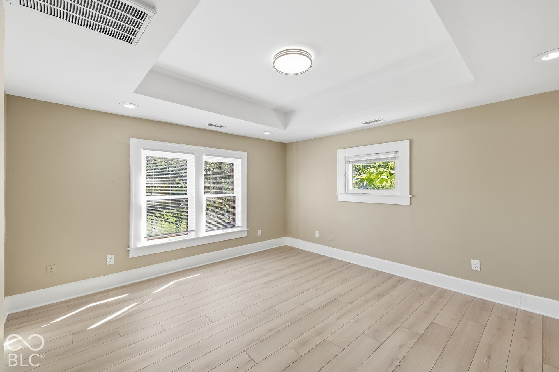 Tray ceiling with a central flush-mount light fixture and recessed lighting