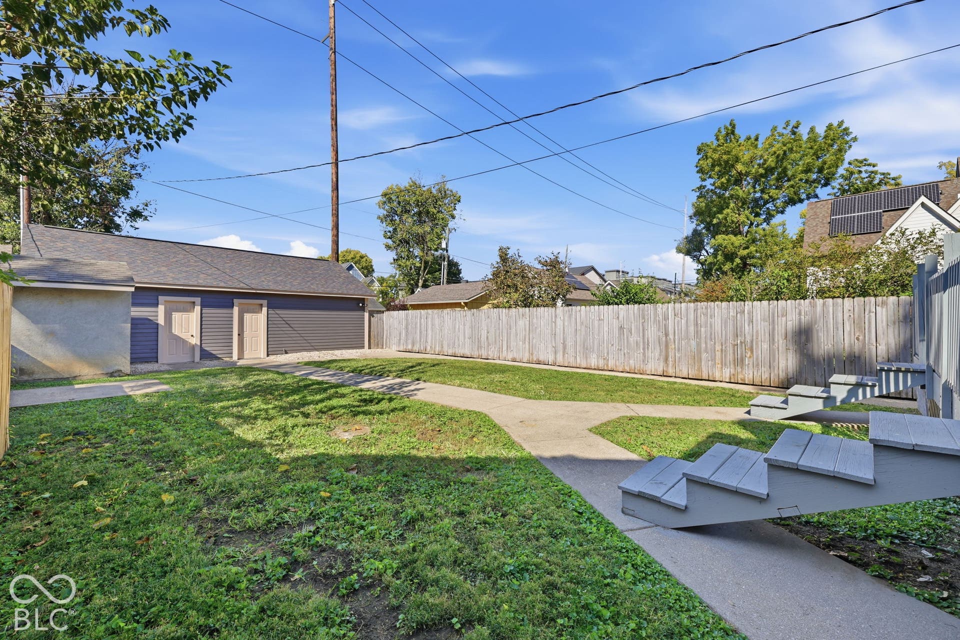Detached garage structure with dual access doors, asphalt shingle roof, and durable siding