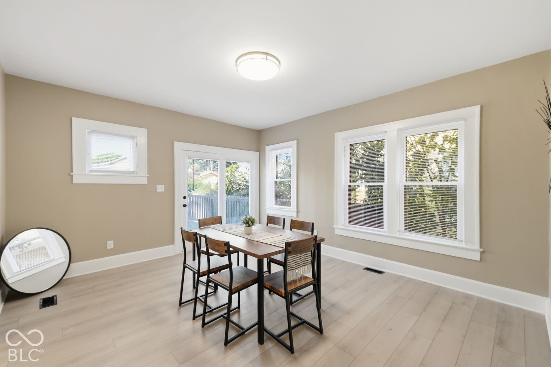 Light wood-finish flooring, recessed lighting, and multiple windows with white trim