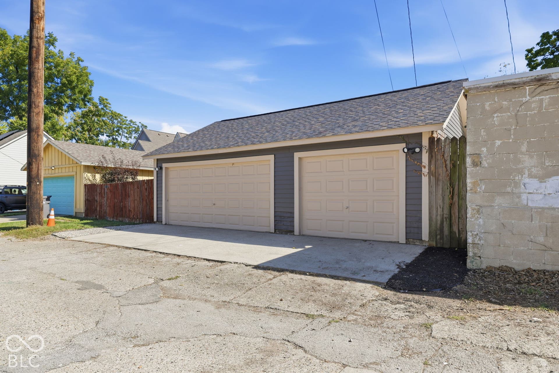 Three-car garage with panel garage doors and dual exterior wall lights