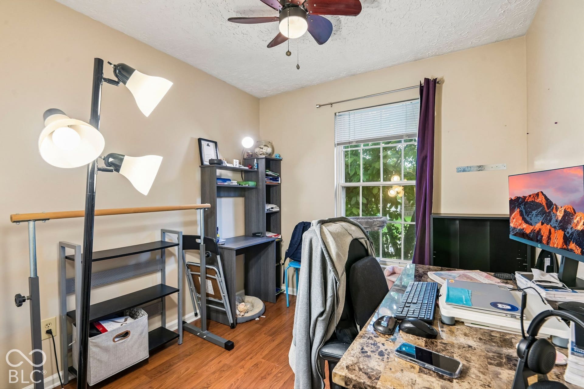 Wood-finish flooring with a ceiling fan overhead