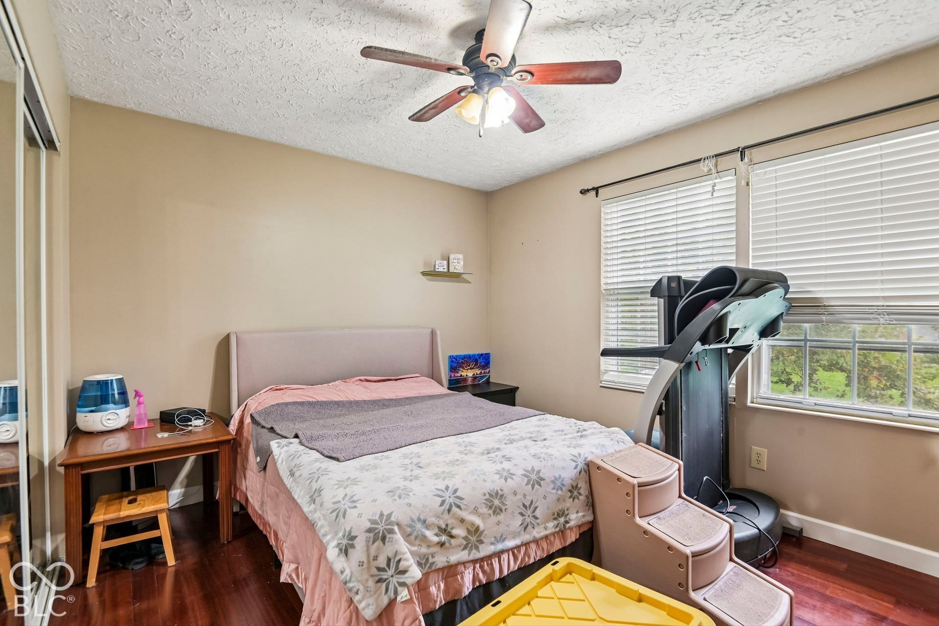 Wood-finish flooring, ceiling fan, and dual windows with blinds