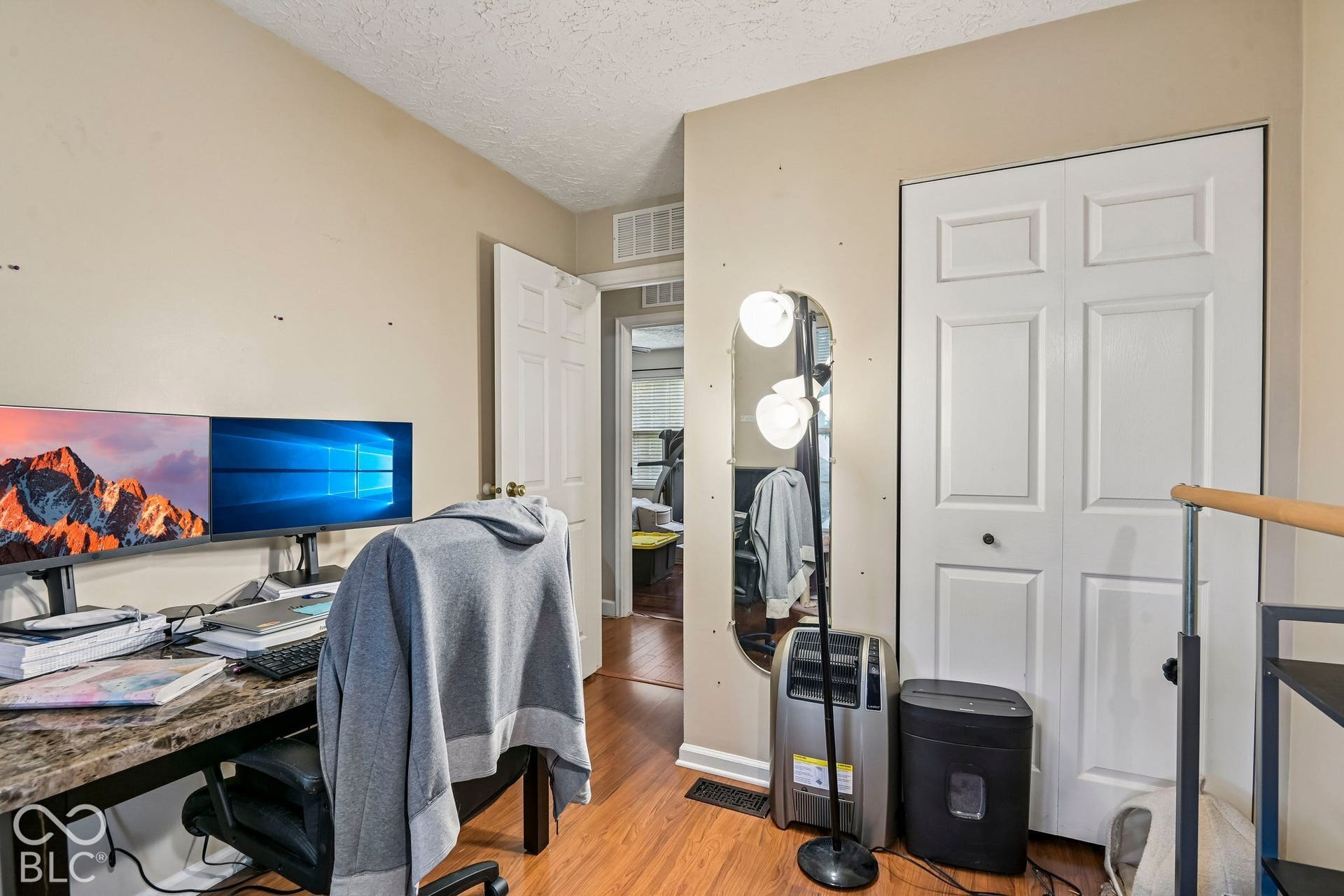 Wood-finish flooring, neutral wall color, and white bi-fold closet doors