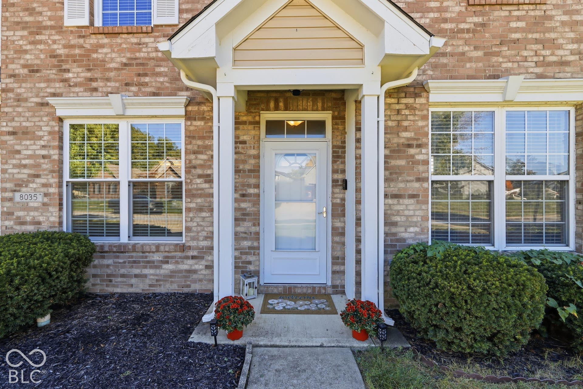 8035 Meadow Bend Lane, Indianapolis, IN 46259 Brick exterior with white trim, covered entryway, and a transom window above the front door