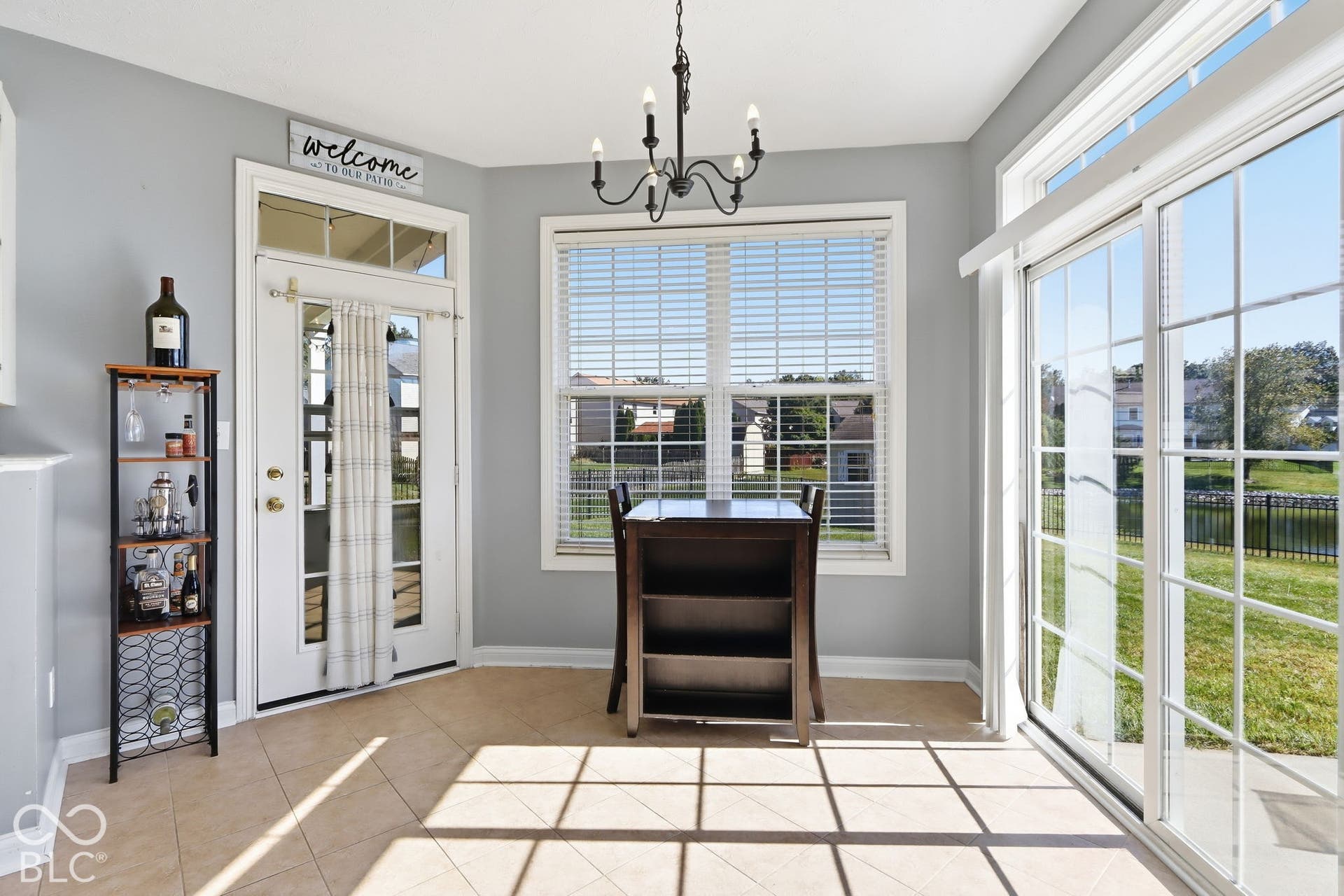 8035 Meadow Bend Lane, Indianapolis, IN 46259 Tile flooring, sliding glass patio door, double-paned window with blinds, overhead chandelier, and a white French door with transom window