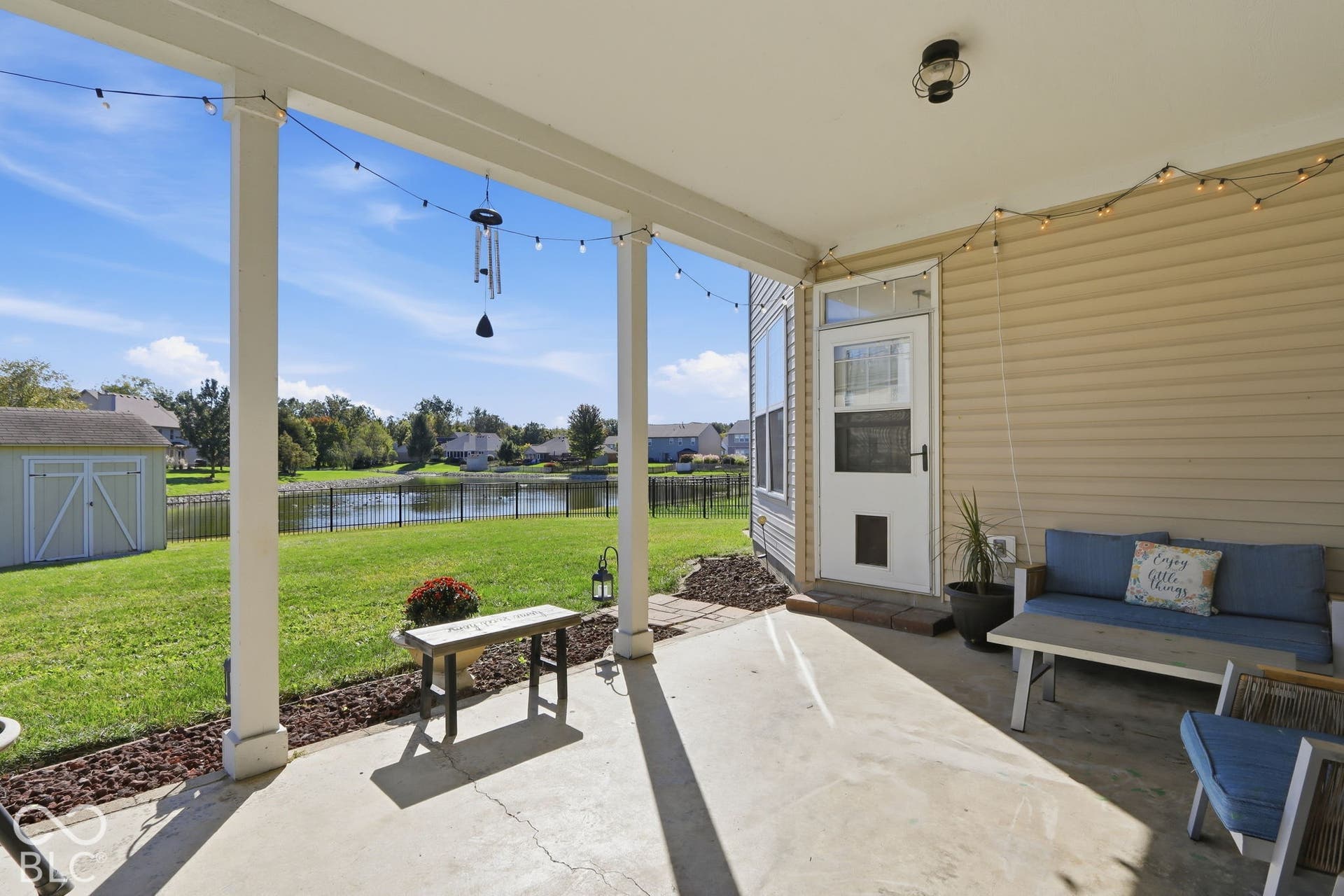8035 Meadow Bend Lane, Indianapolis, IN 46259 Covered concrete patio with a water feature, fenced yard, and a storage shed