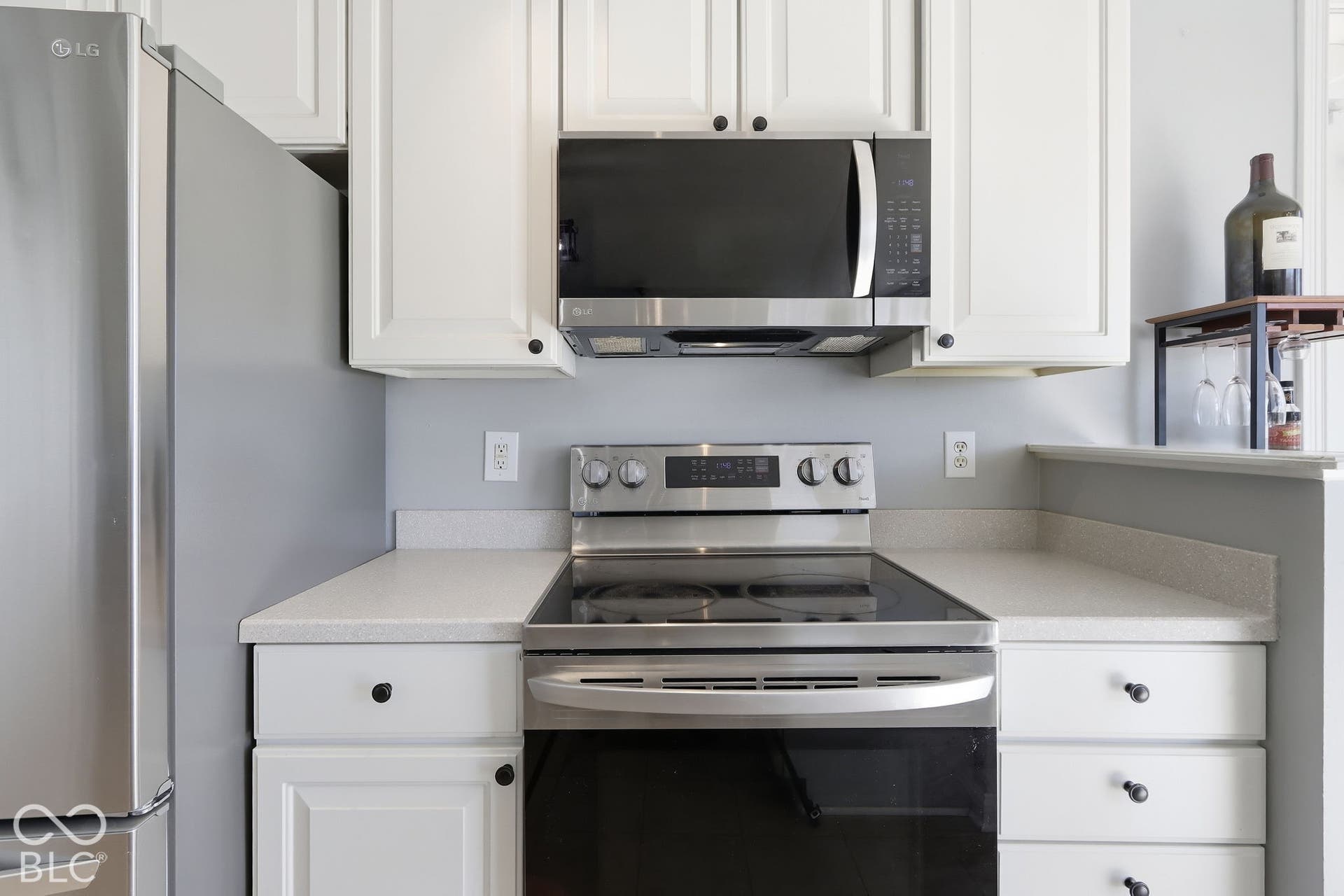 8035 Meadow Bend Lane, Indianapolis, IN 46259 Stainless steel refrigerator, stainless steel range with electric cooktop, stainless steel microwave, white cabinetry with black hardware, and light-colored countertops