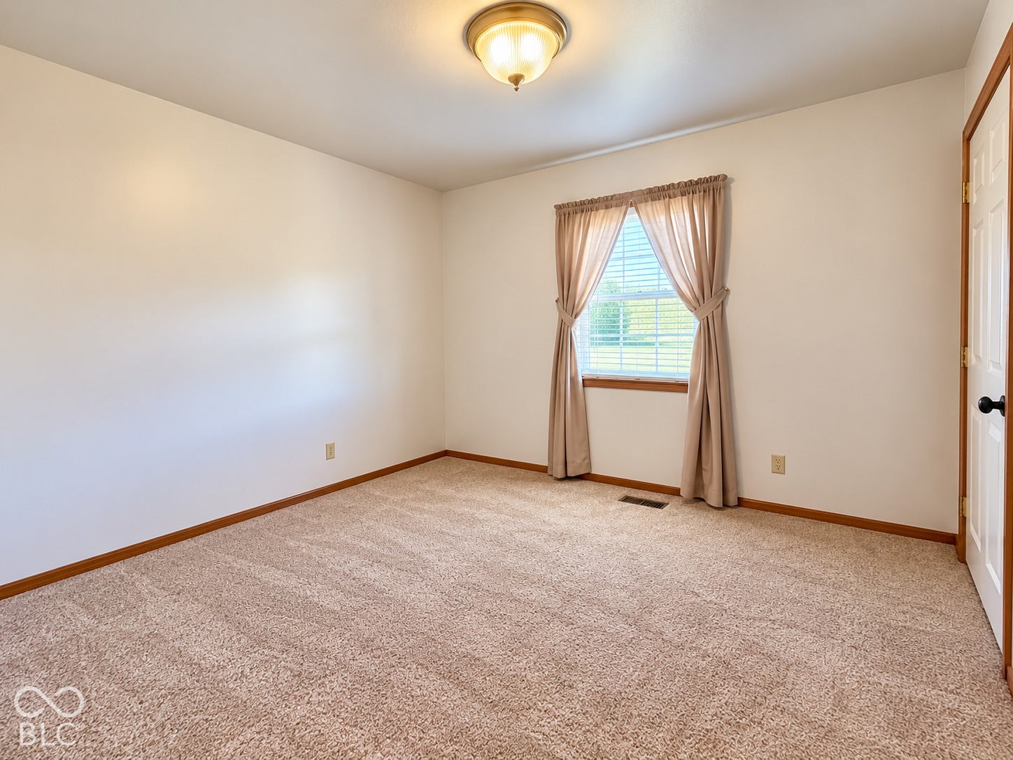 Neutral paint palette, textured carpet flooring, single window, and flush mount lighting fixture