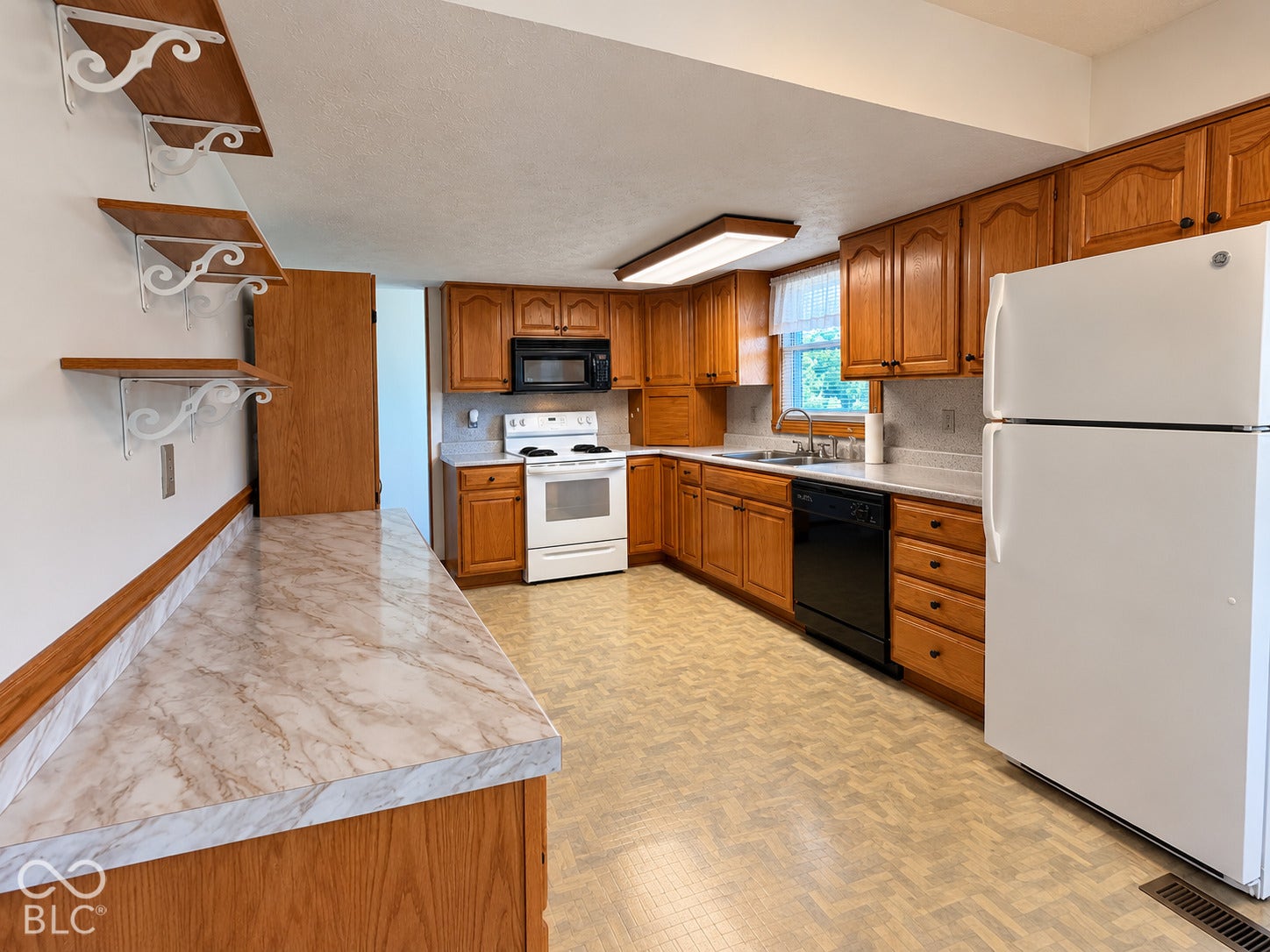 Kitchen featuring wood cabinetry, a built-in microwave, white refrigerator, and black dishwasher
