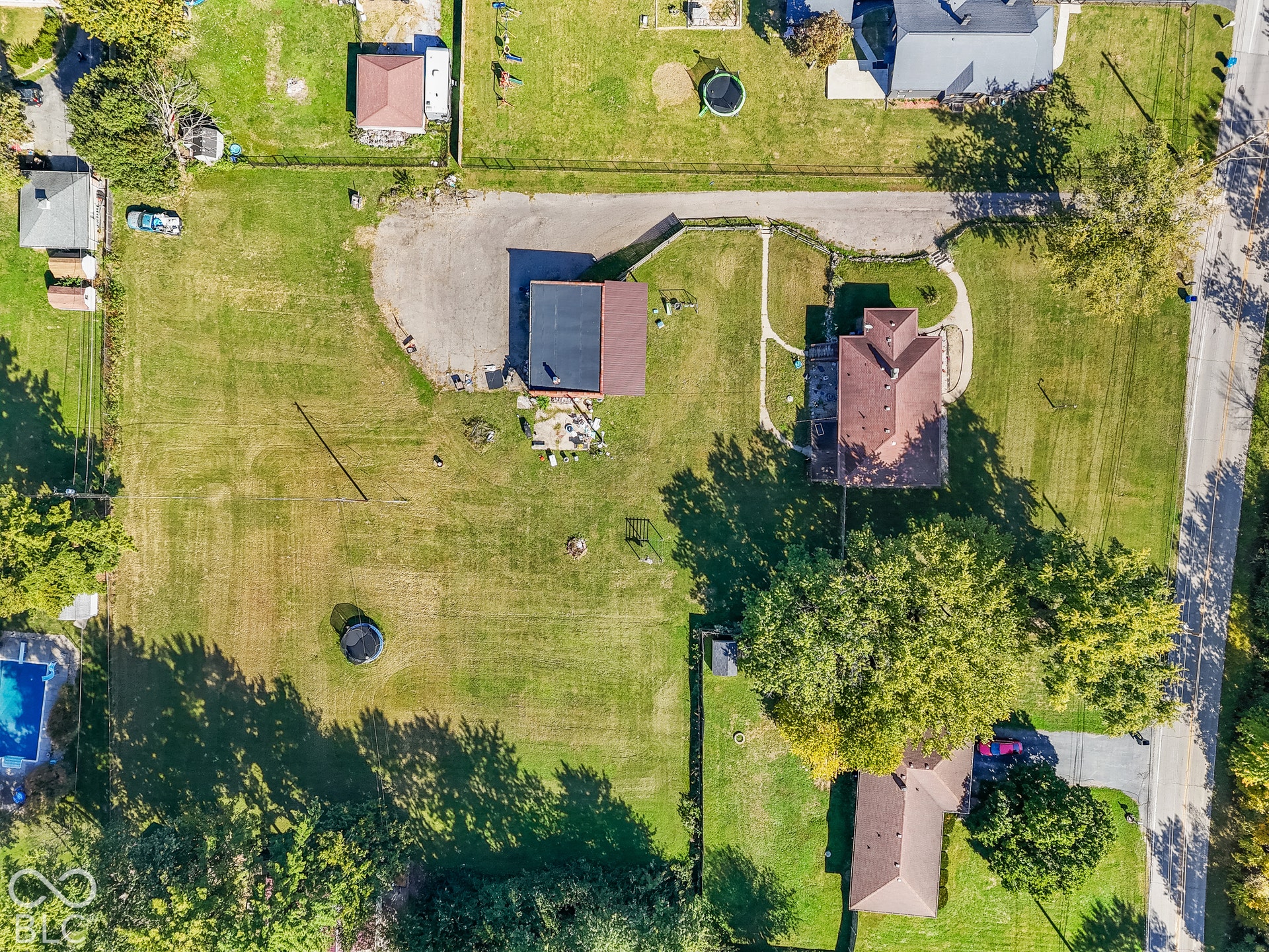 Expansive lot featuring a primary residence, detached outbuilding, and mature trees