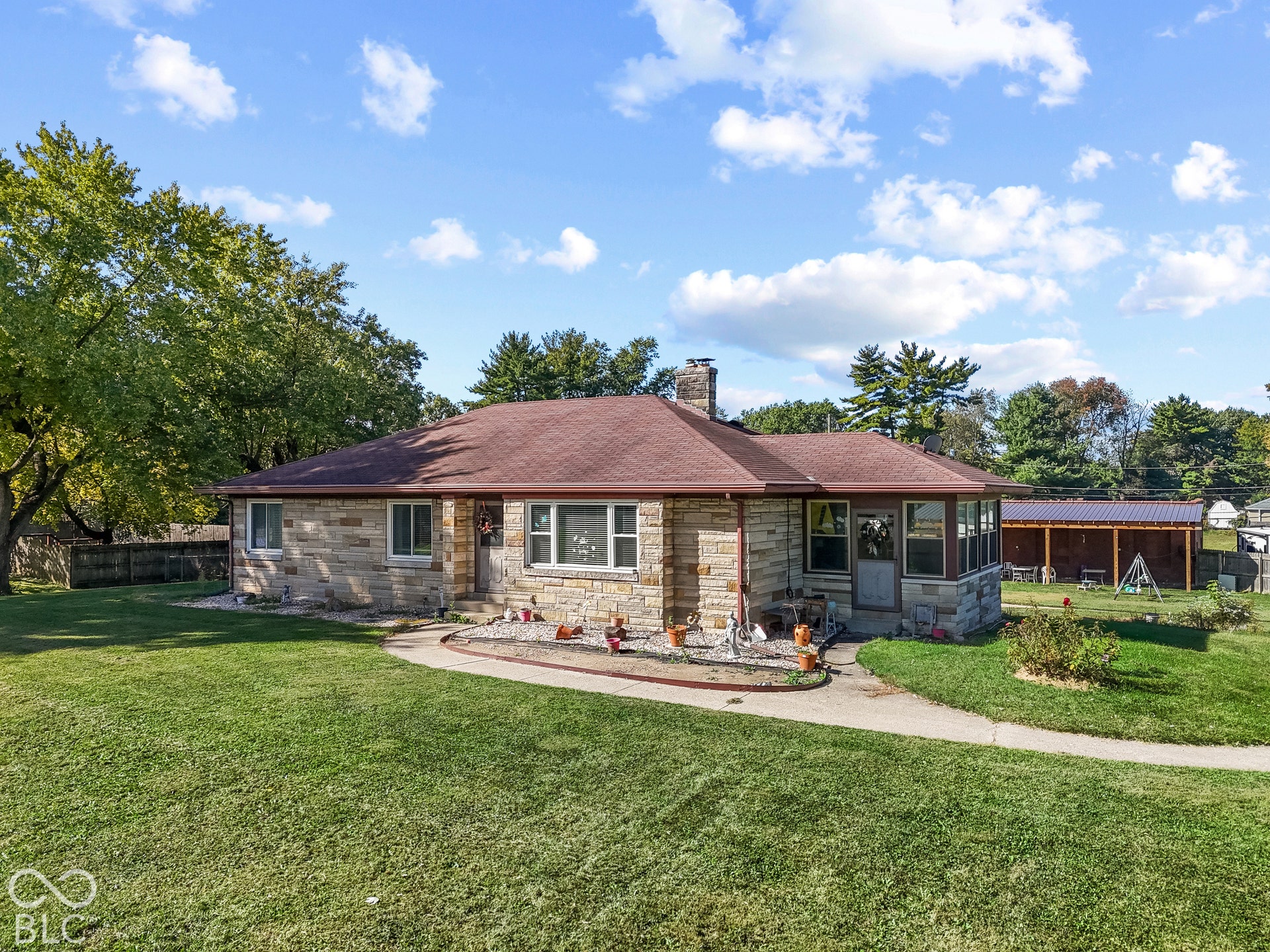 Stone veneer exterior with a red shingle roof
