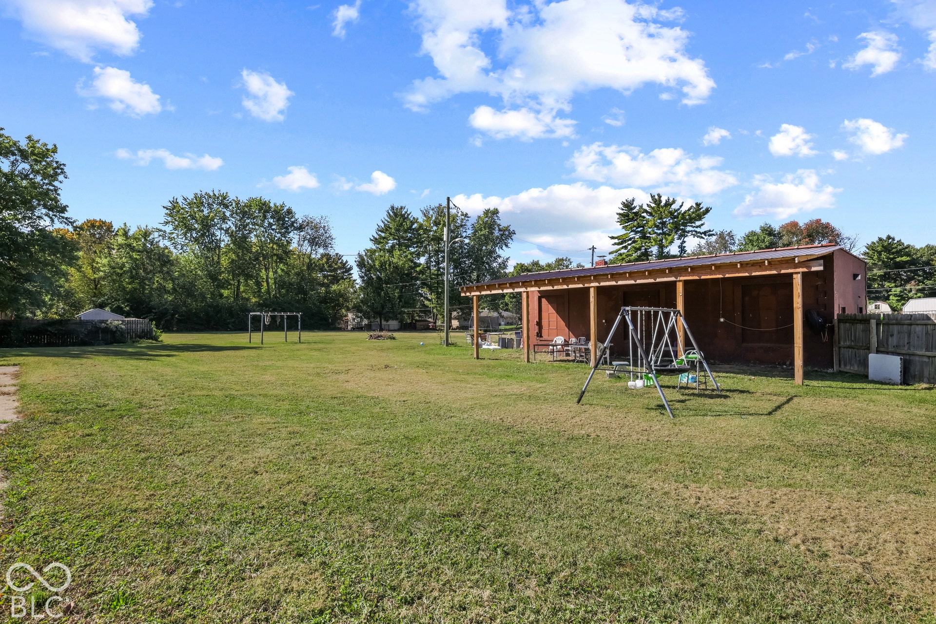 Expansive lawn featuring a covered patio structure with a metal roof
