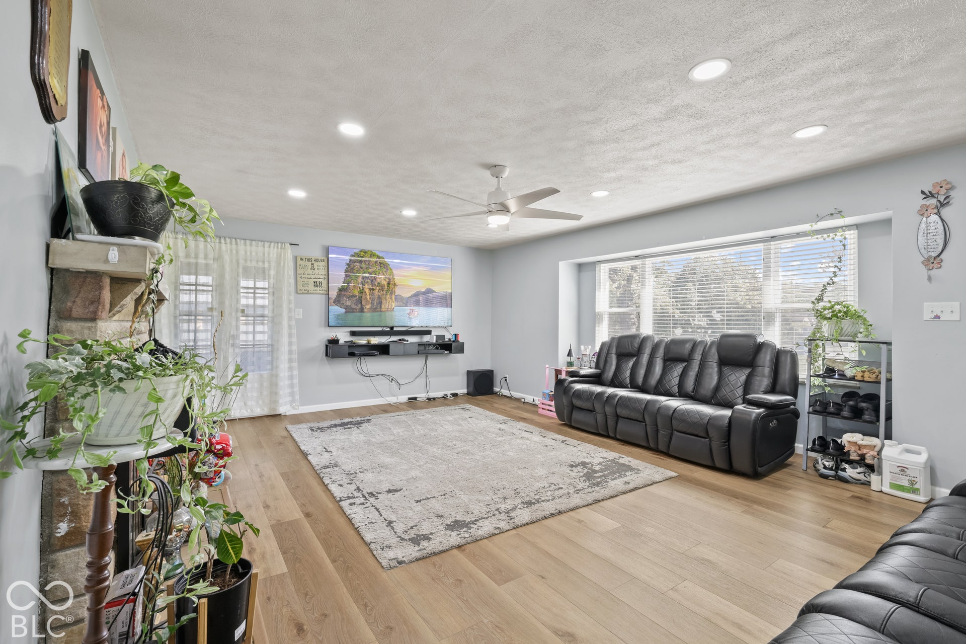 Recessed lighting, ceiling fan, wood-finish flooring, light gray wall paint, and large window