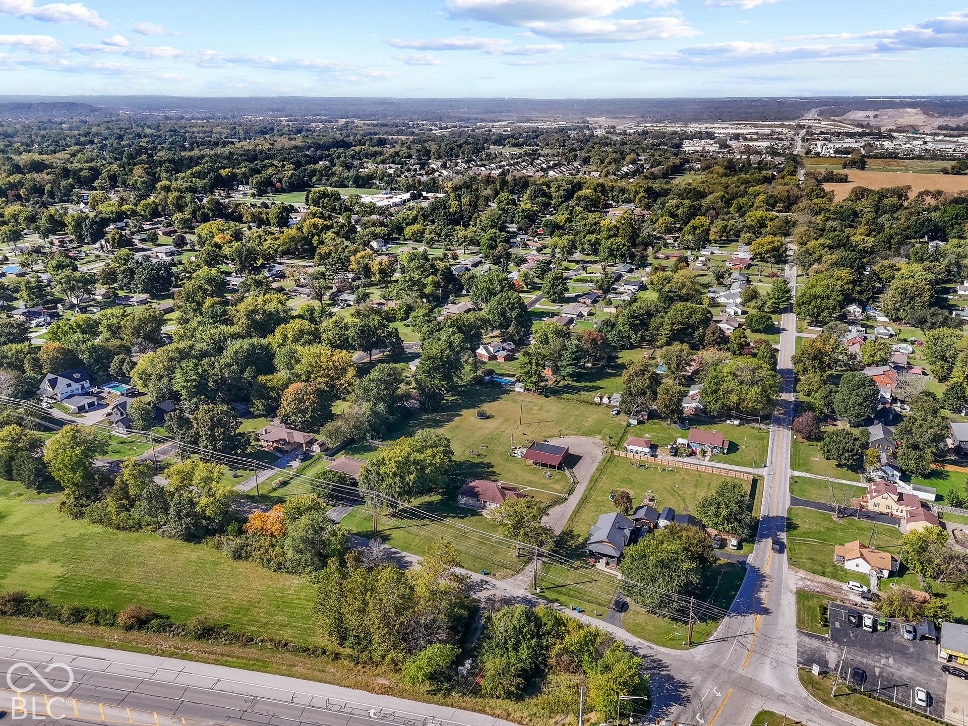 Aerial view showcasing a sprawling residential property nestled within a mature tree-lined neighborhood