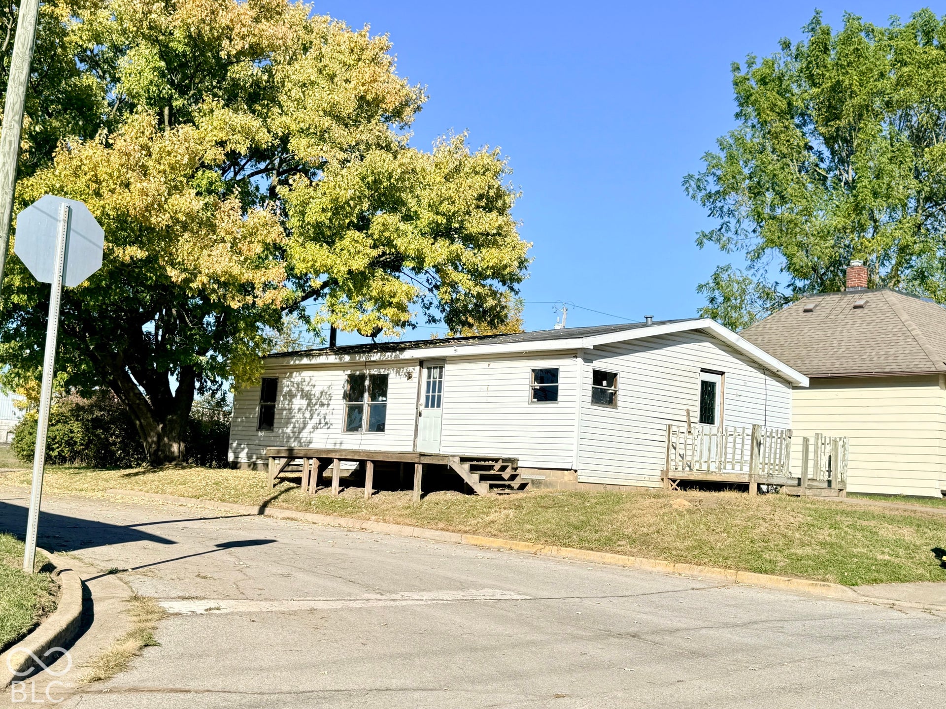 White siding exterior with multiple windows and a front entry door