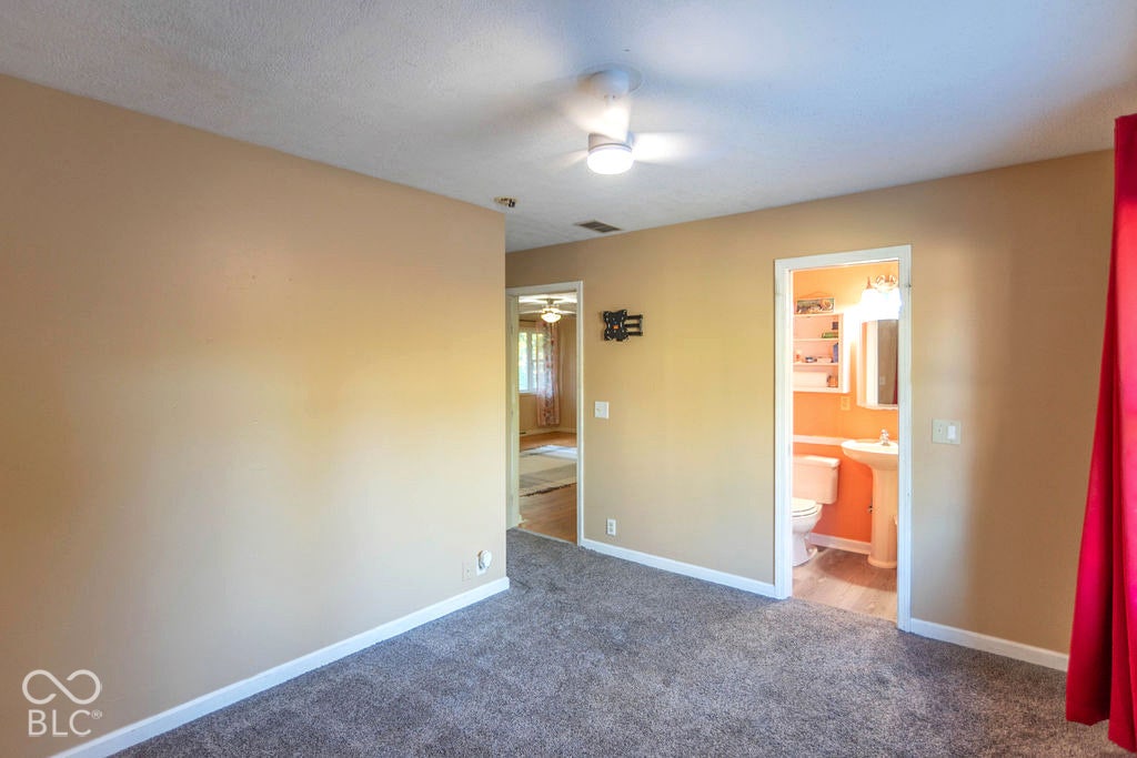 Recessed ceiling fan, carpet flooring, and a bathroom featuring a pedestal sink and wall-mounted vanity light