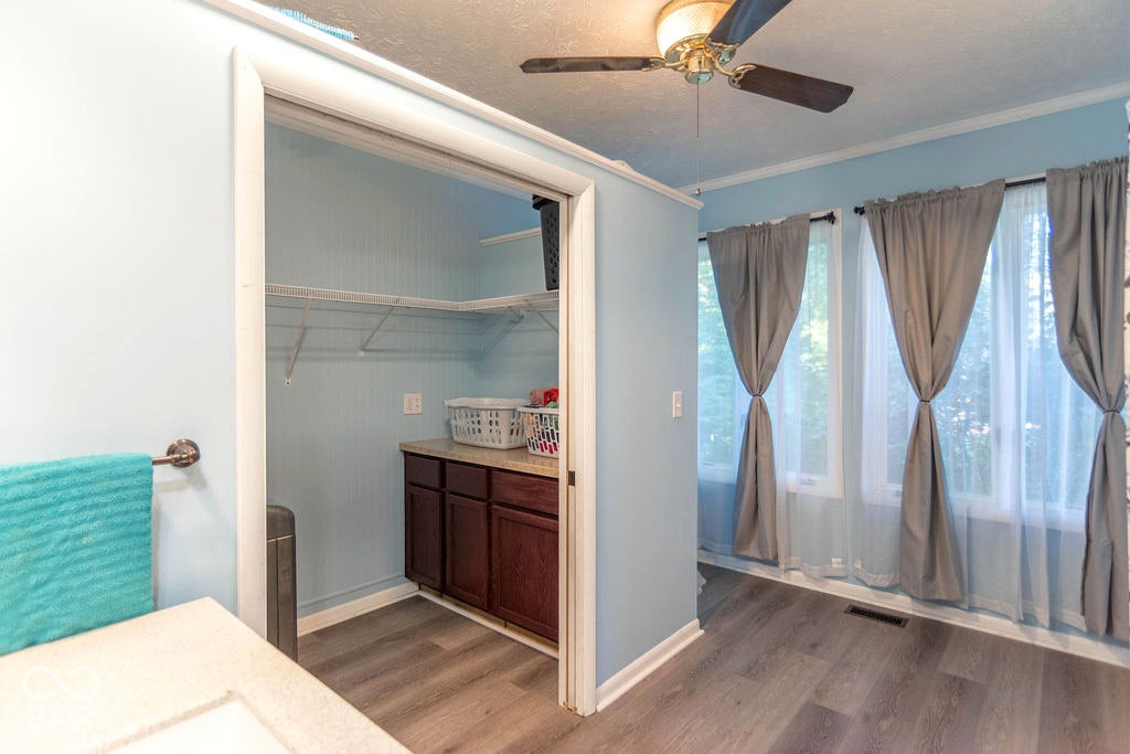 Recessed laundry area with wood-finish flooring
