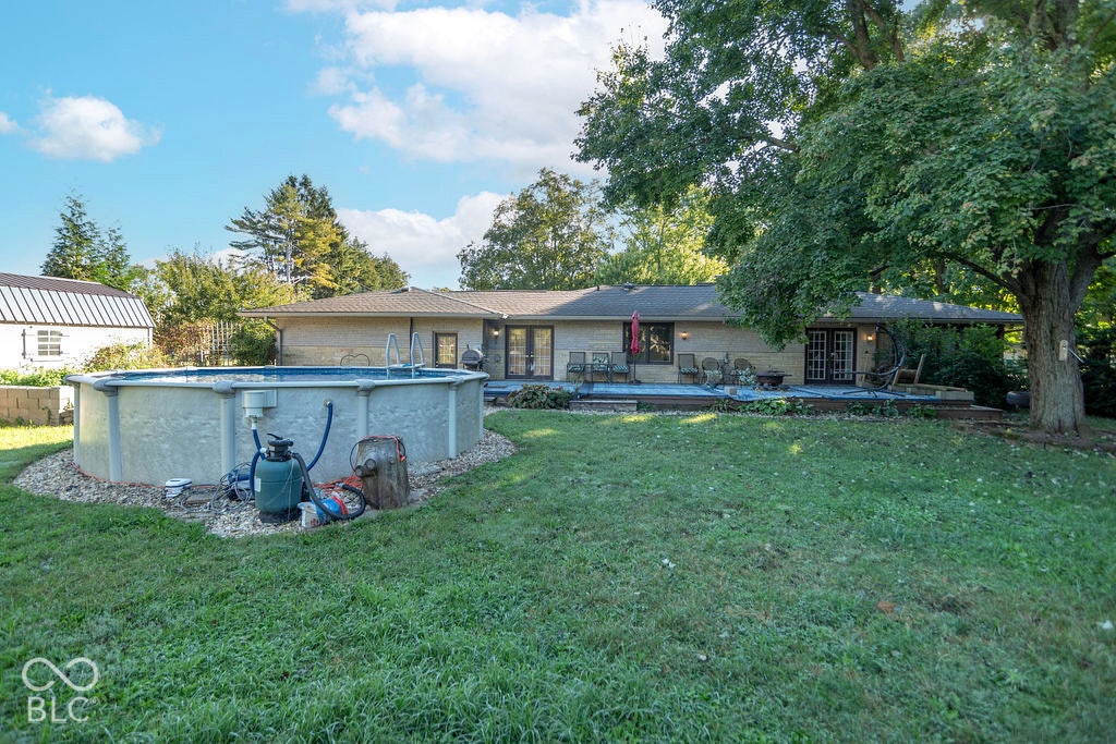 Expansive backyard with an above-ground pool, dedicated deck area, and mature trees