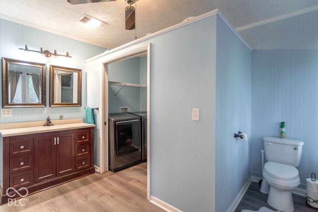 Dark wood-finish vanity with dual framed mirrors, light-toned countertop, and undermount sink