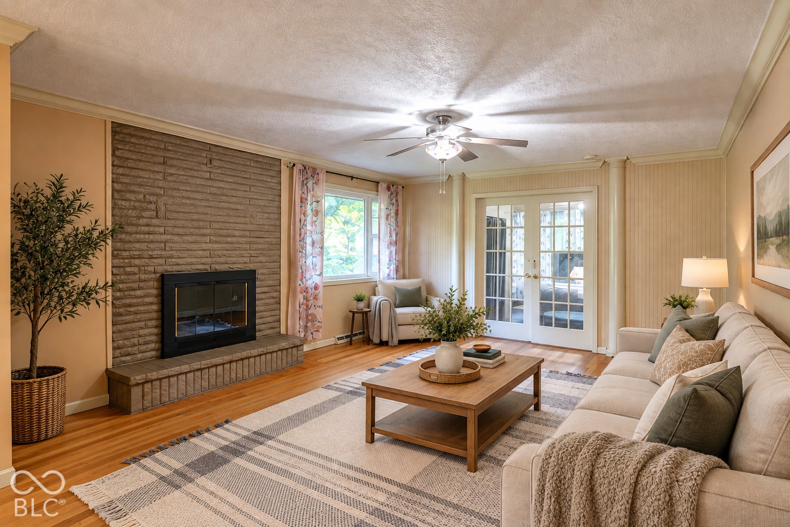 Virtually Altered - Stone-clad fireplace with hearth, wood-finish flooring, white French doors, ceiling fan, and crown molding