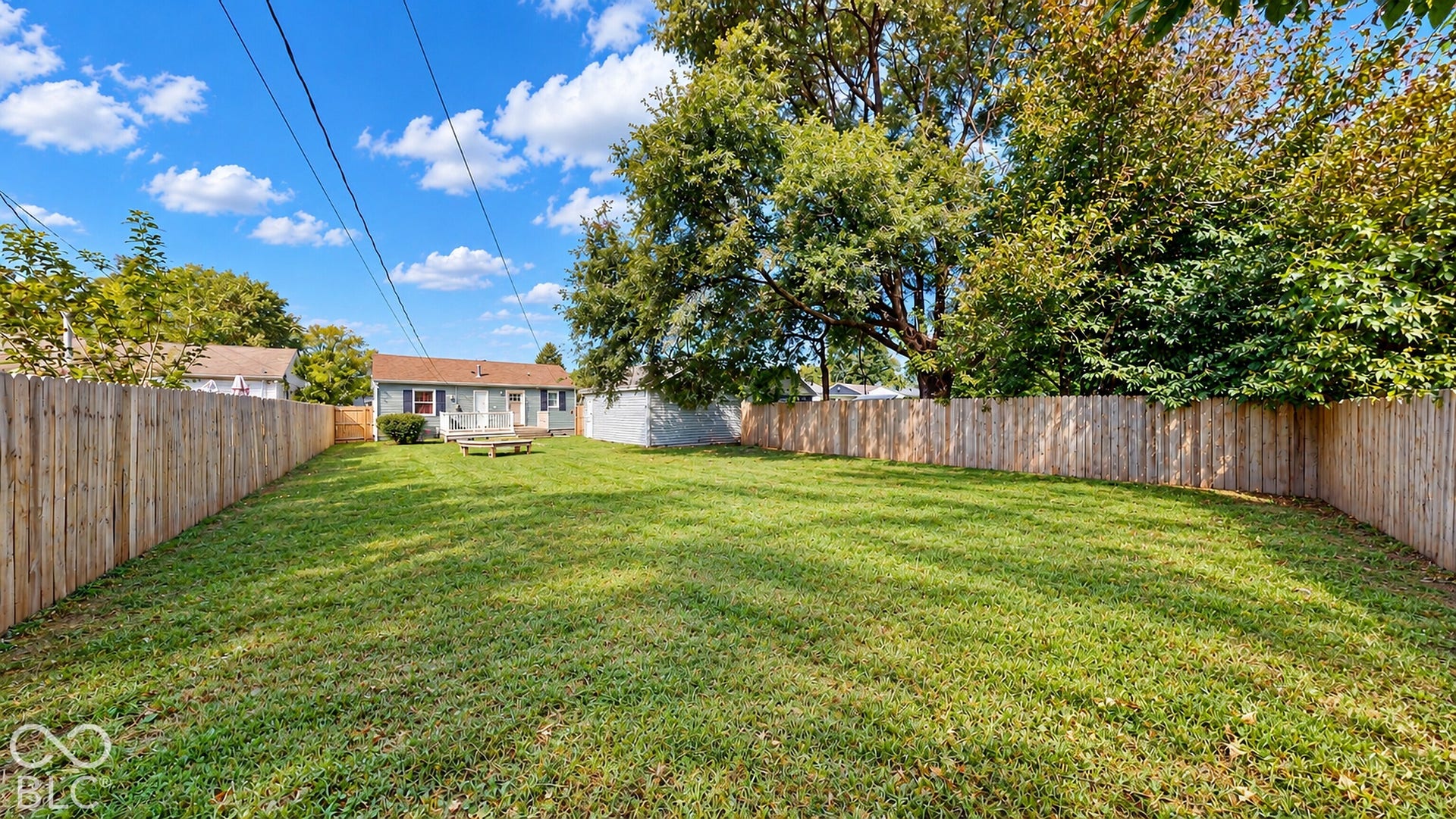 Virtually Altered - Expansive lawn area enclosed by a wood privacy fence