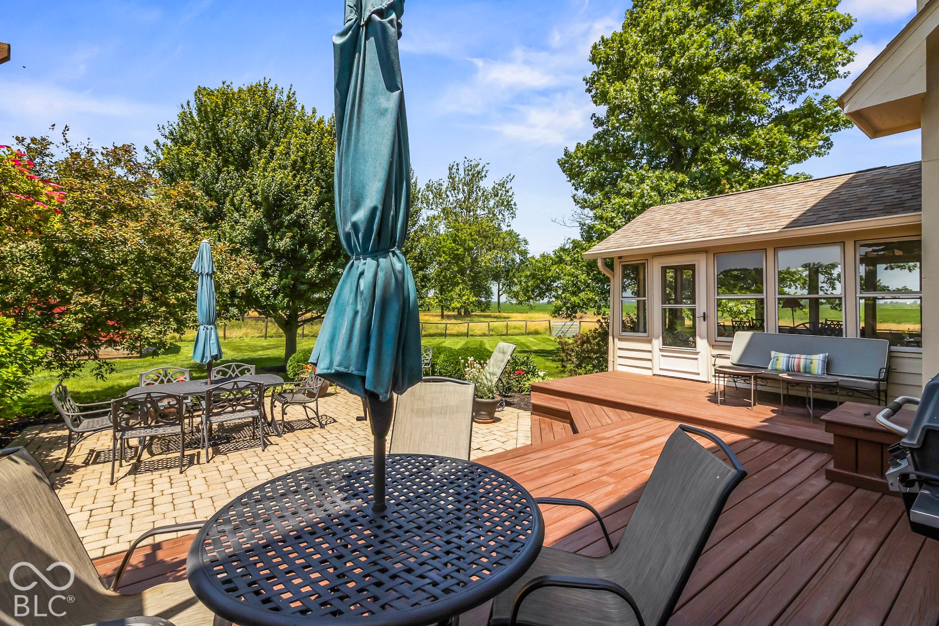 10954 N County Road 150 Road E, Pittsboro, IN 46167 Multi-level wood deck, light-toned paver patio, expansive green lawn, and mature perimeter trees