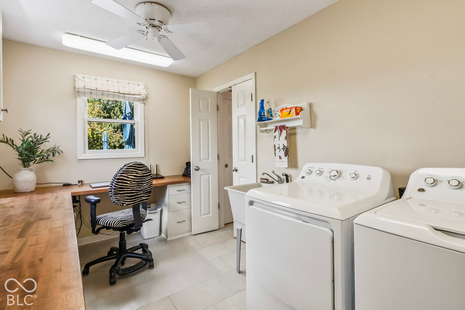 10954 N County Road 150 Road E, Pittsboro, IN 46167 Laundry room featuring neutral tile flooring, a built-in wood-finish workspace, a utility sink, and a ceiling-mounted light fixture