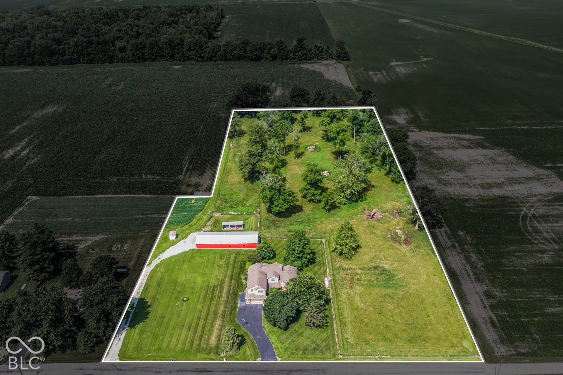 10954 N County Road 150 Road E, Pittsboro, IN 46167 Expansive acreage featuring mature trees, a detached red barn, a paved driveway, and established green space
