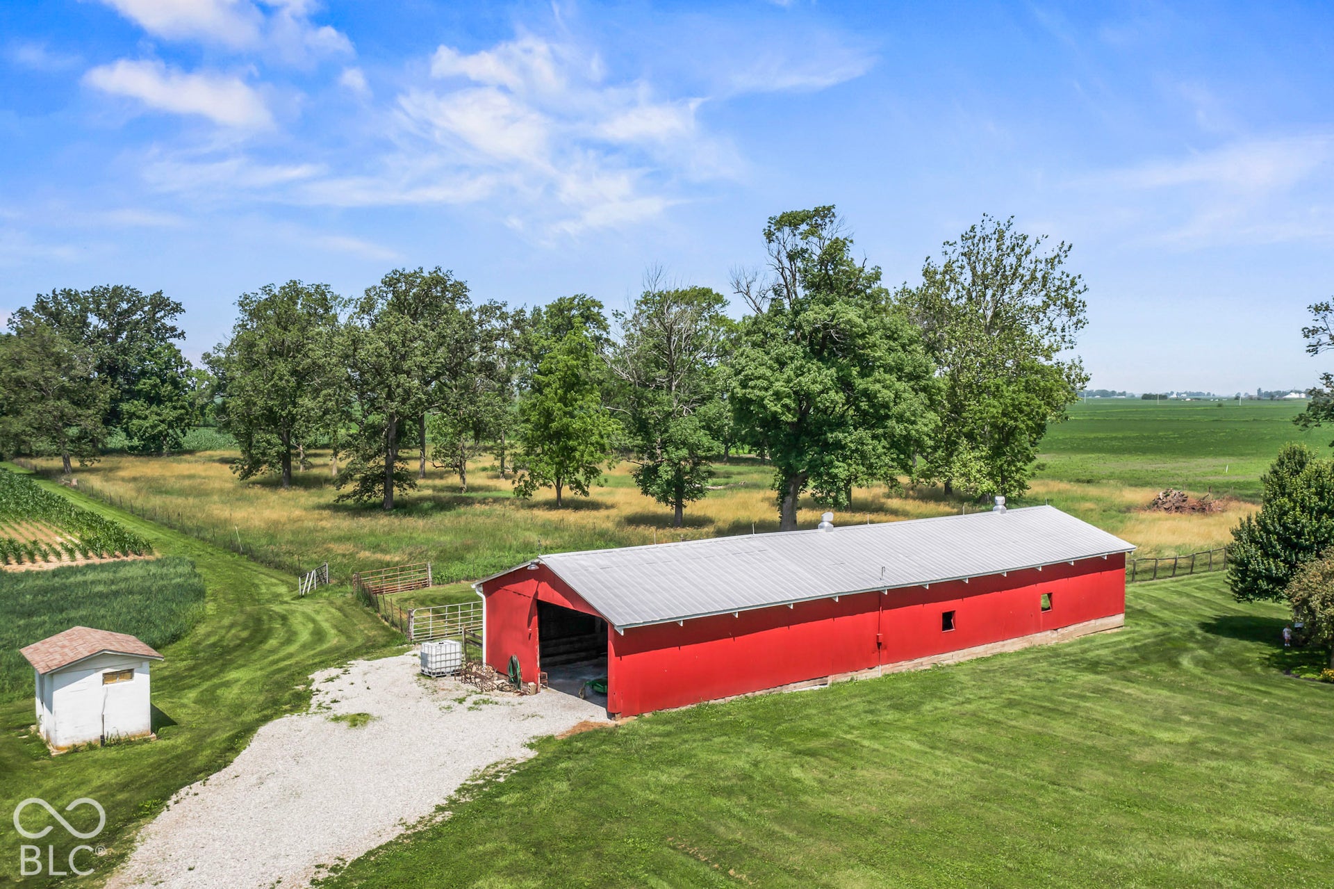 10954 N County Road 150 Road E, Pittsboro, IN 46167 Expansive grounds featuring a red-sided metal-roofed barn, a secondary utility structure, open pastures, and mature trees