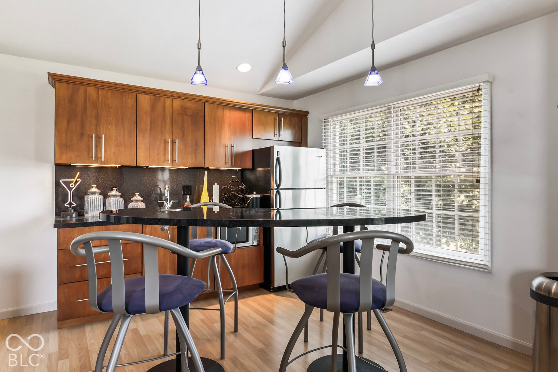 10954 N County Road 150 Road E, Pittsboro, IN 46167 Kitchen area featuring natural-finish wood cabinetry, dark stone-style countertops, stainless steel refrigerator, recessed lighting, and a vaulted ceiling
