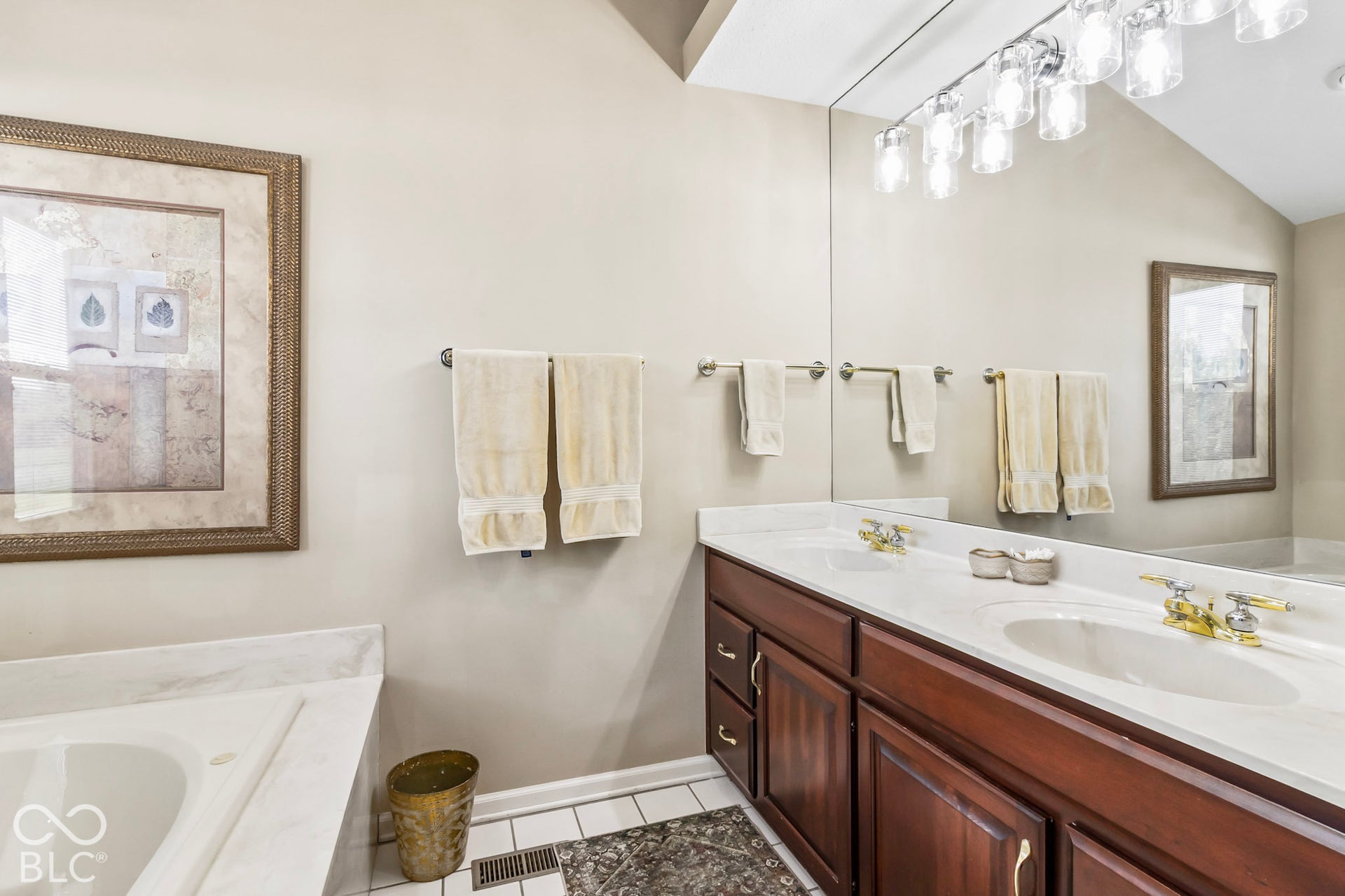 10954 N County Road 150 Road E, Pittsboro, IN 46167 Double vanity featuring wood cabinetry, stone countertops, dual integrated sinks, and a large-format vanity mirror with integrated multi-bulb lighting