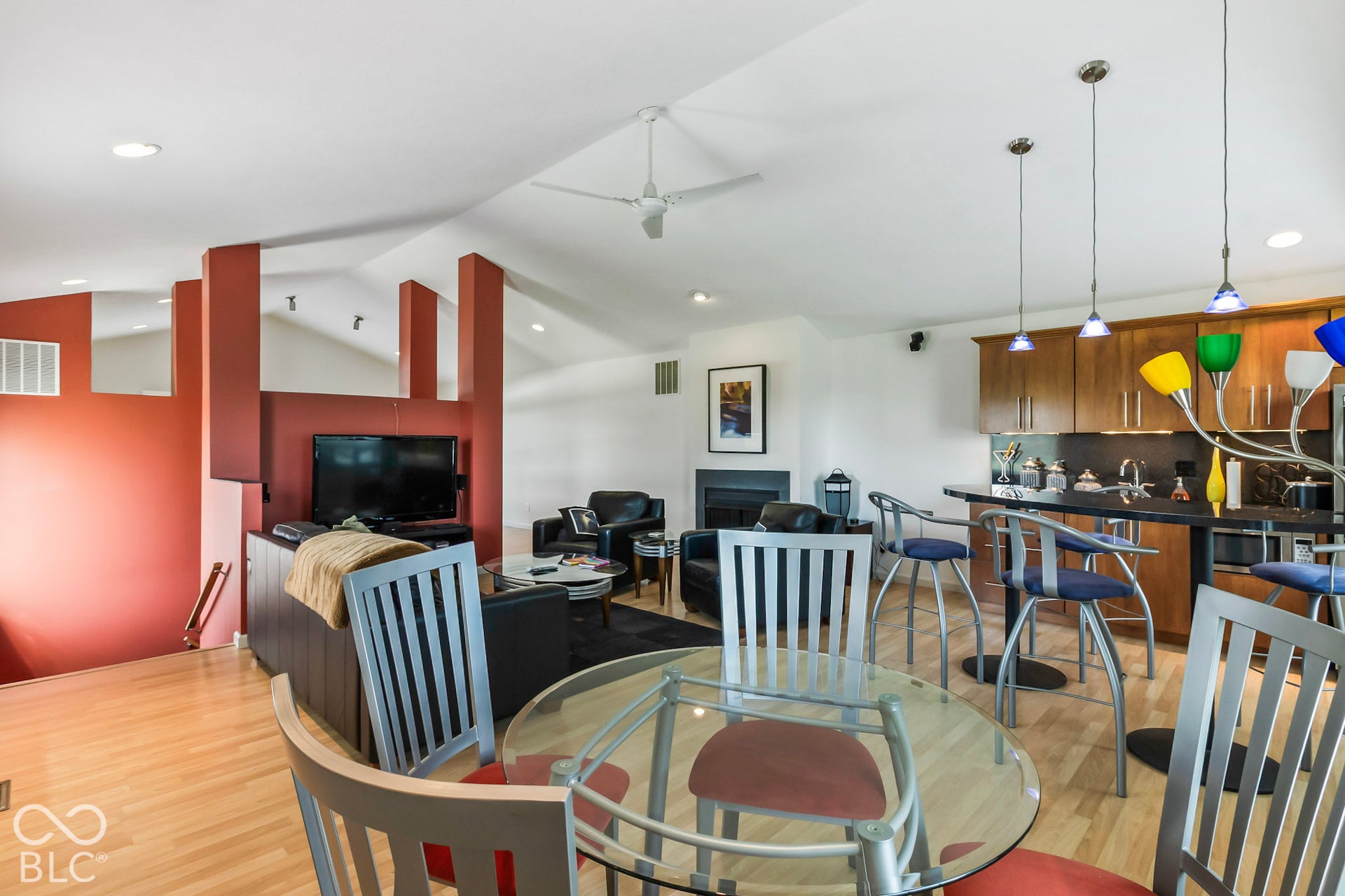10954 N County Road 150 Road E, Pittsboro, IN 46167 Vaulted ceilings featuring recessed lighting and a central ceiling fan, kitchen cabinetry with stone-surface breakfast bar, and a fireplace with a black surround