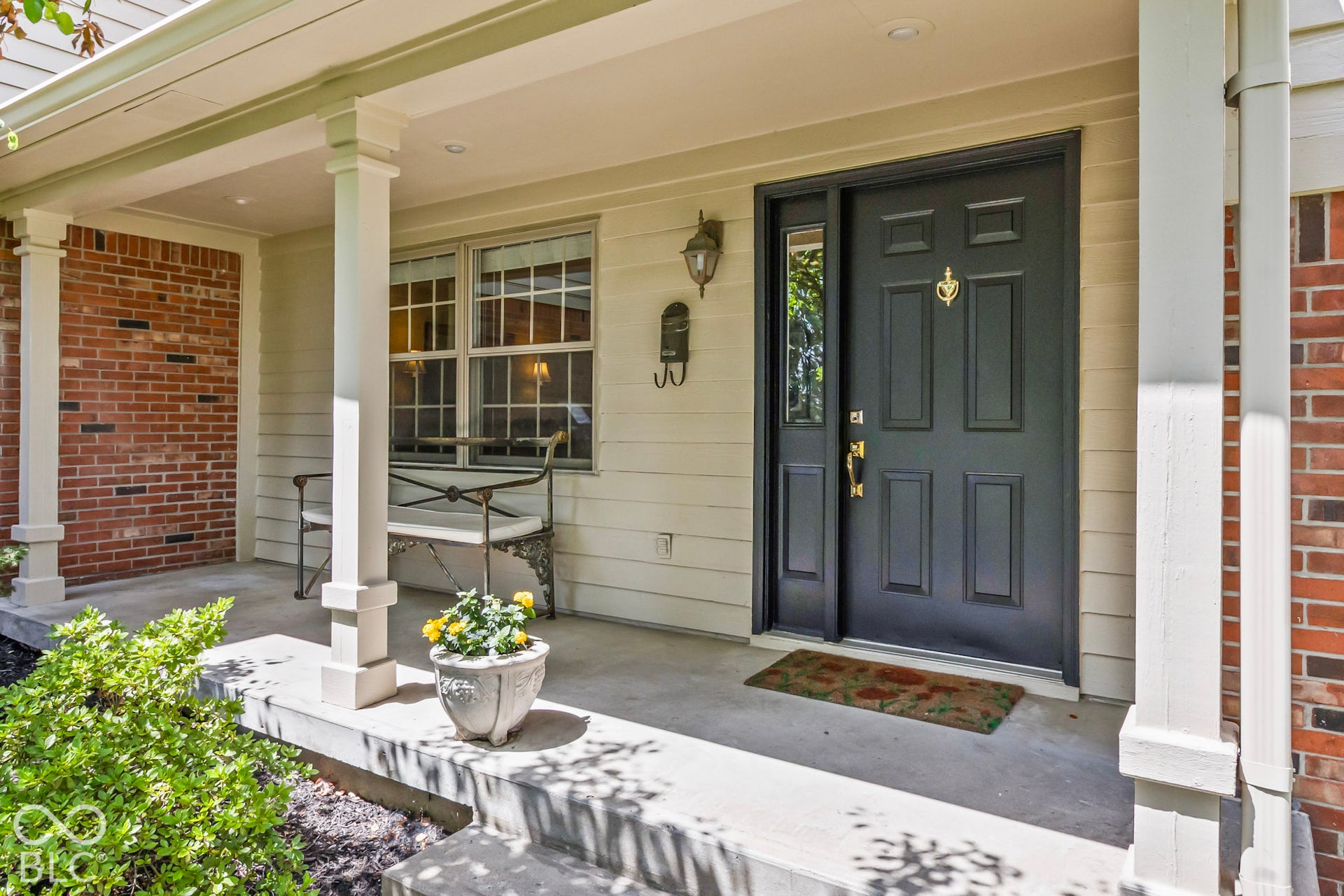 10954 N County Road 150 Road E, Pittsboro, IN 46167 Covered front porch featuring brick masonry accents, boxed columns, horizontal lap siding, and a paneled entry door with a sidelight
