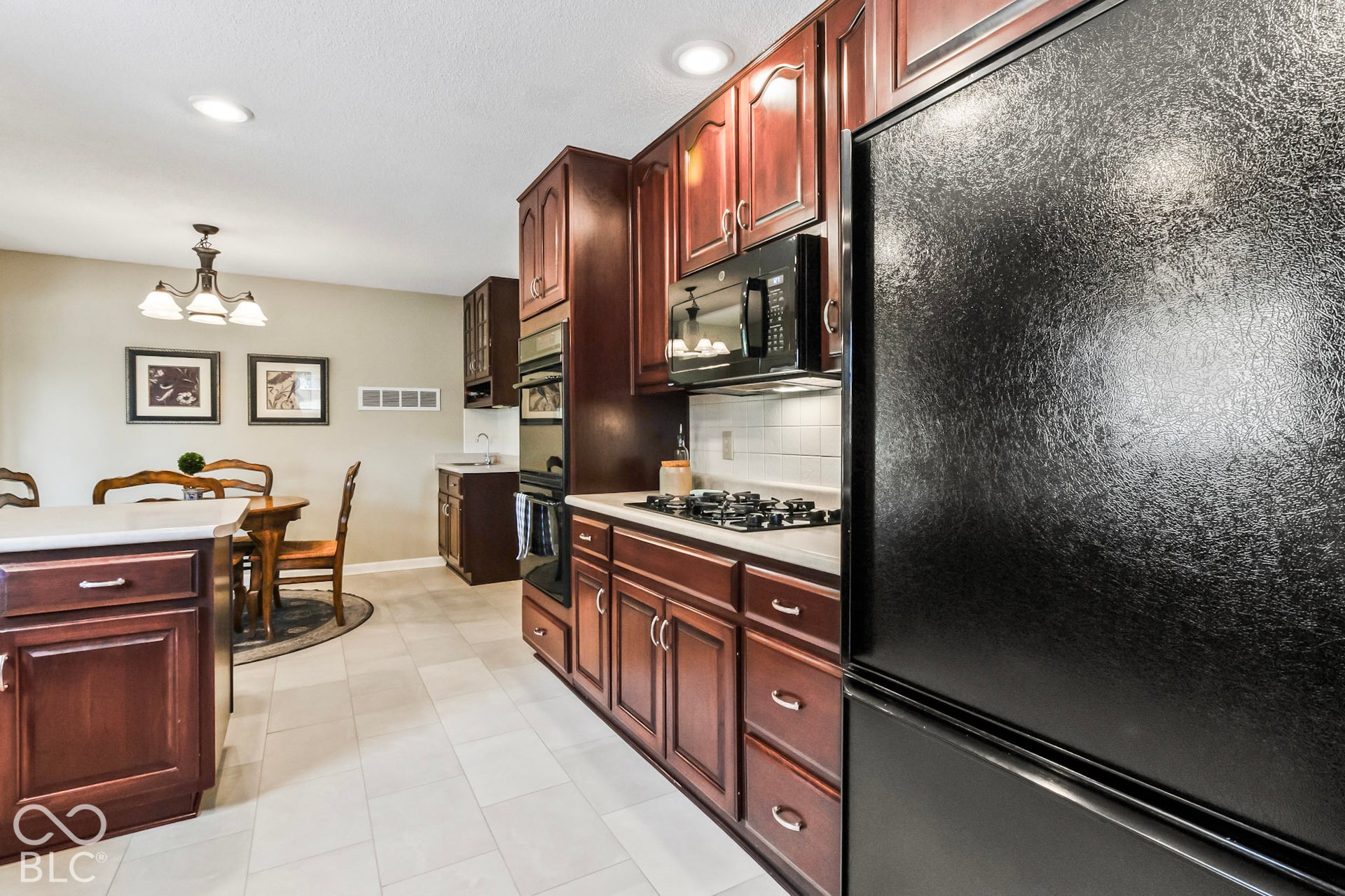 10954 N County Road 150 Road E, Pittsboro, IN 46167 Kitchen featuring dark-finish cabinetry, built-in wall oven, inset gas cooktop, tile flooring, and light-toned solid surface countertops