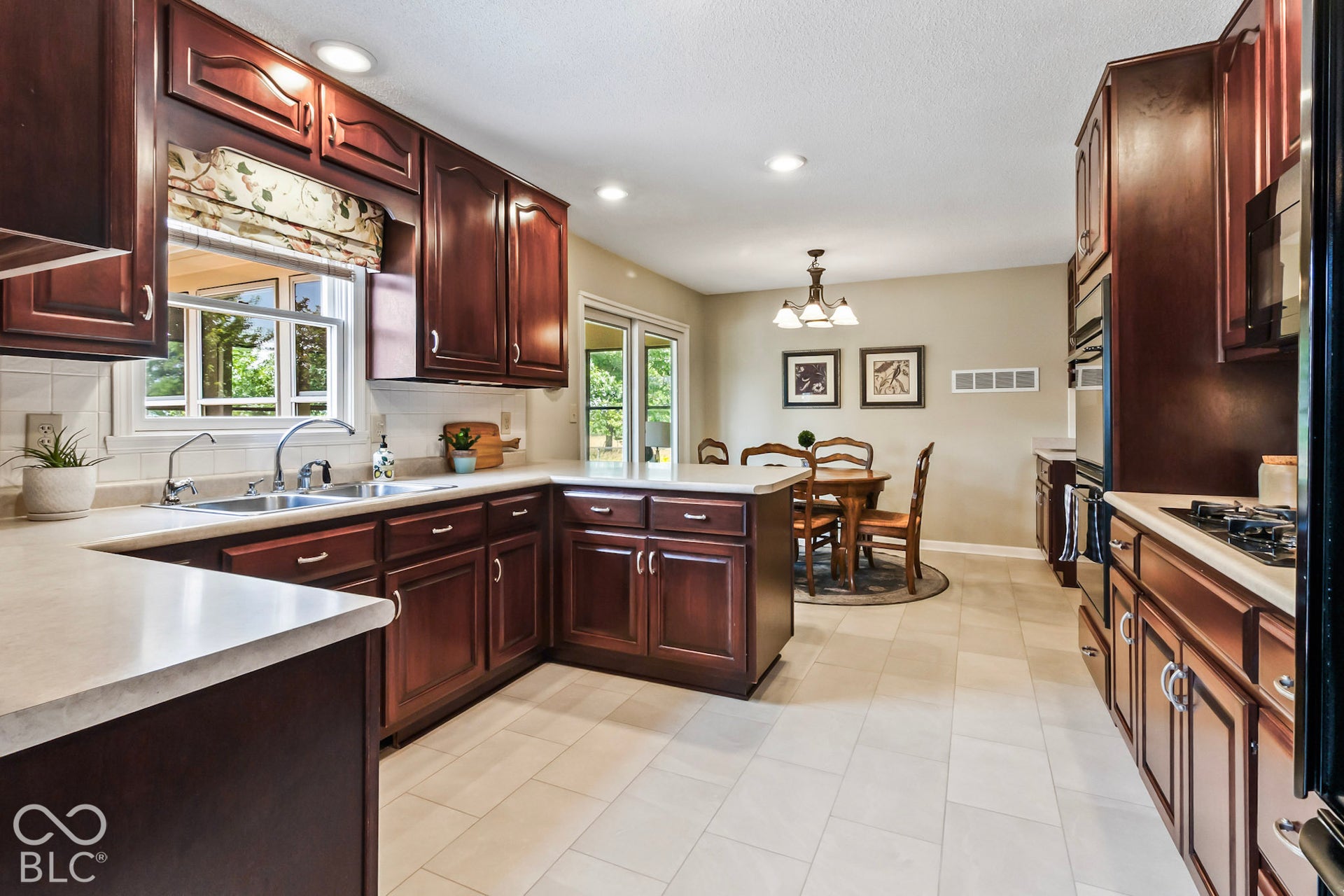 10954 N County Road 150 Road E, Pittsboro, IN 46167 Kitchen featuring dark wood cabinetry, solid surface countertops, tile flooring, recessed lighting, and integrated wall oven