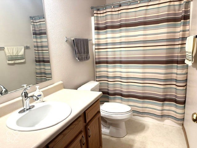 1712 Austin Drive, Lebanon, IN 46052 Bathroom featuring a vanity with a drop-in sink, wood-finish cabinetry, and a full-width mirror