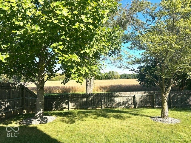 1712 Austin Drive, Lebanon, IN 46052 Fenced yard with mature trees, manicured lawn, and natural surroundings