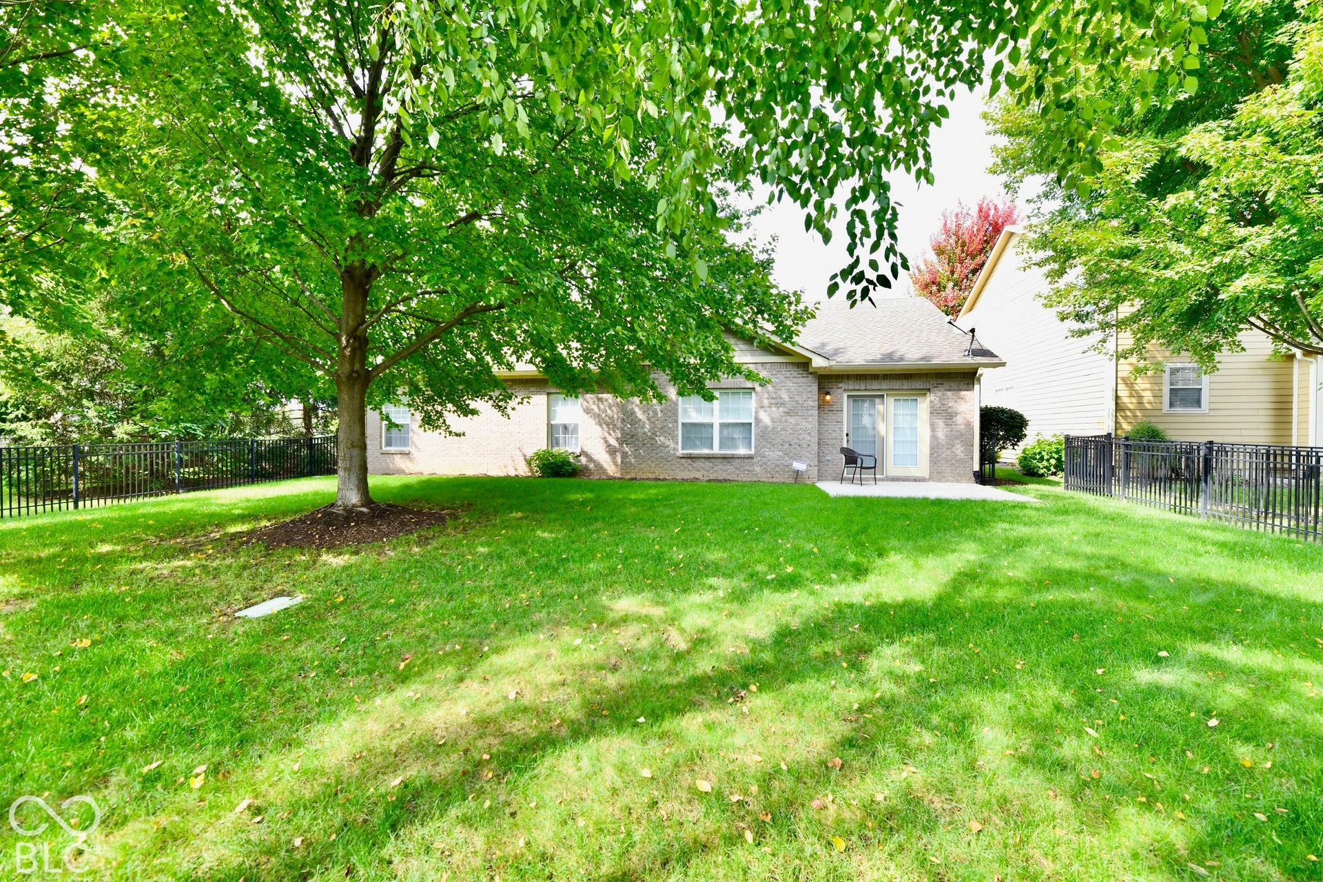 Featuring mature trees and a fenced in backyard with a concrete patio