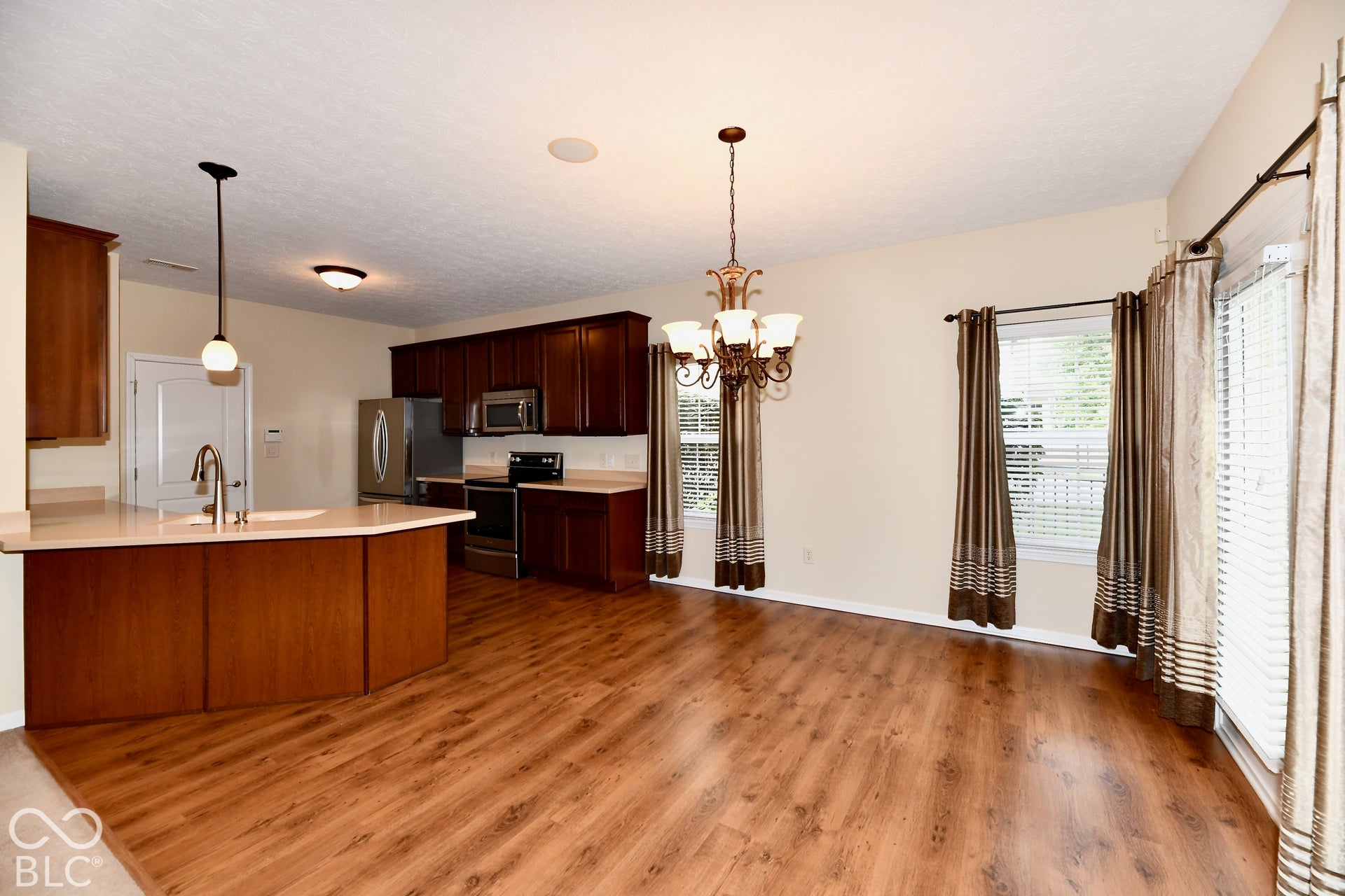 Kitchen with wood-finish flooring, dark wood cabinetry, and stainless steel appliances